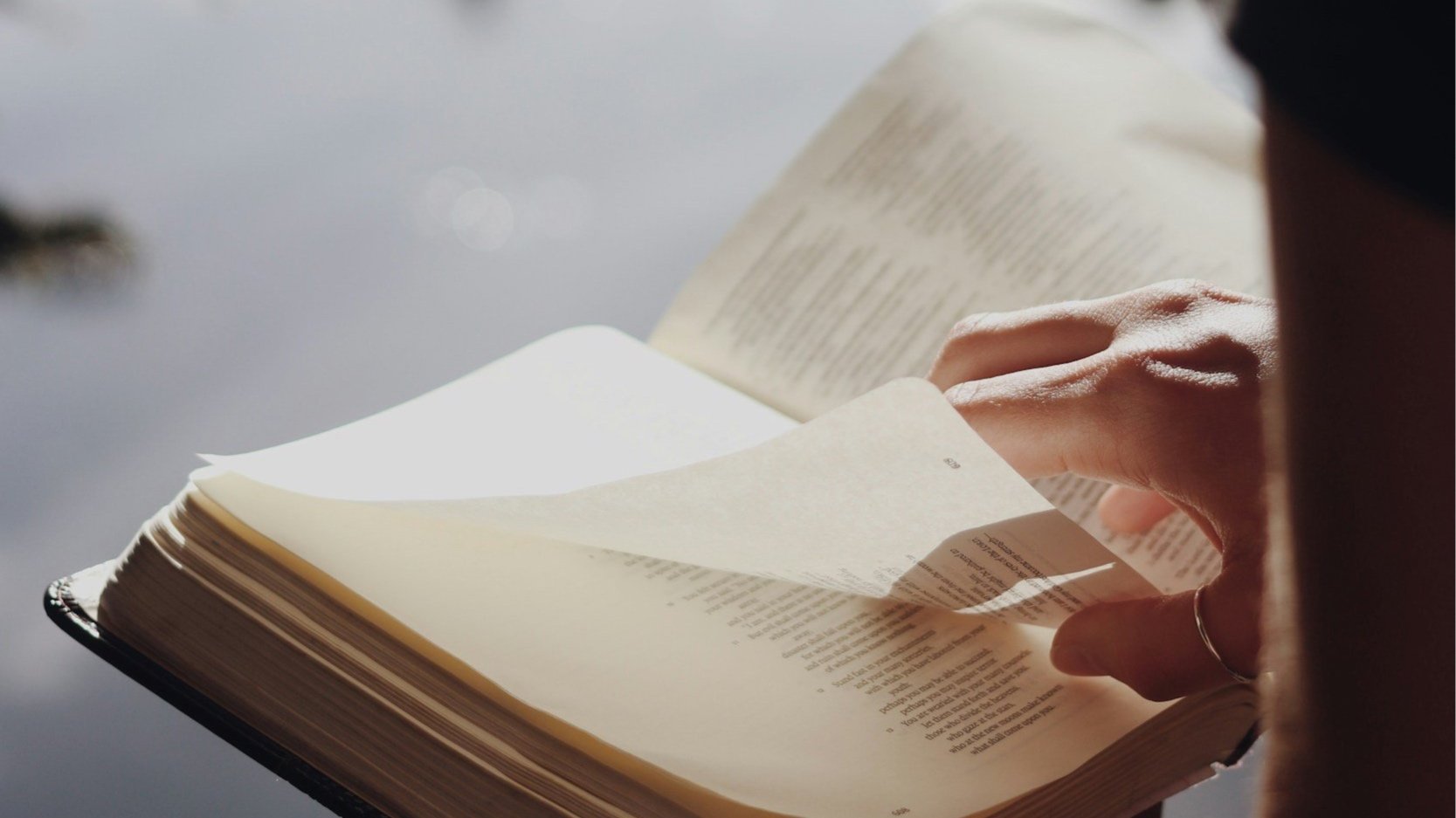 A person holds a Bible and is exploring the question: How do I know if God is real.