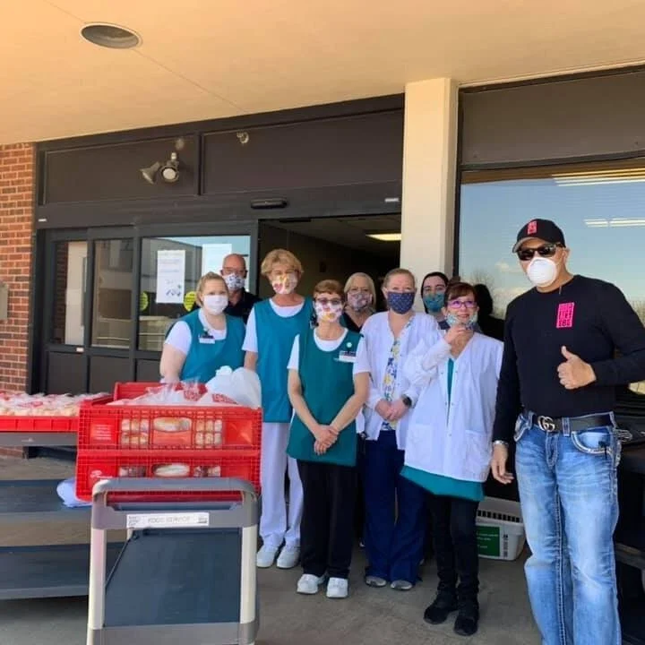 A business owner poses with a photo with frontline workers during the COVID-19 pandemic. After almost closing his restaurant due to quarantine health regulations, he felt God urging him to donate food. God answered his prayer in an amazing way.