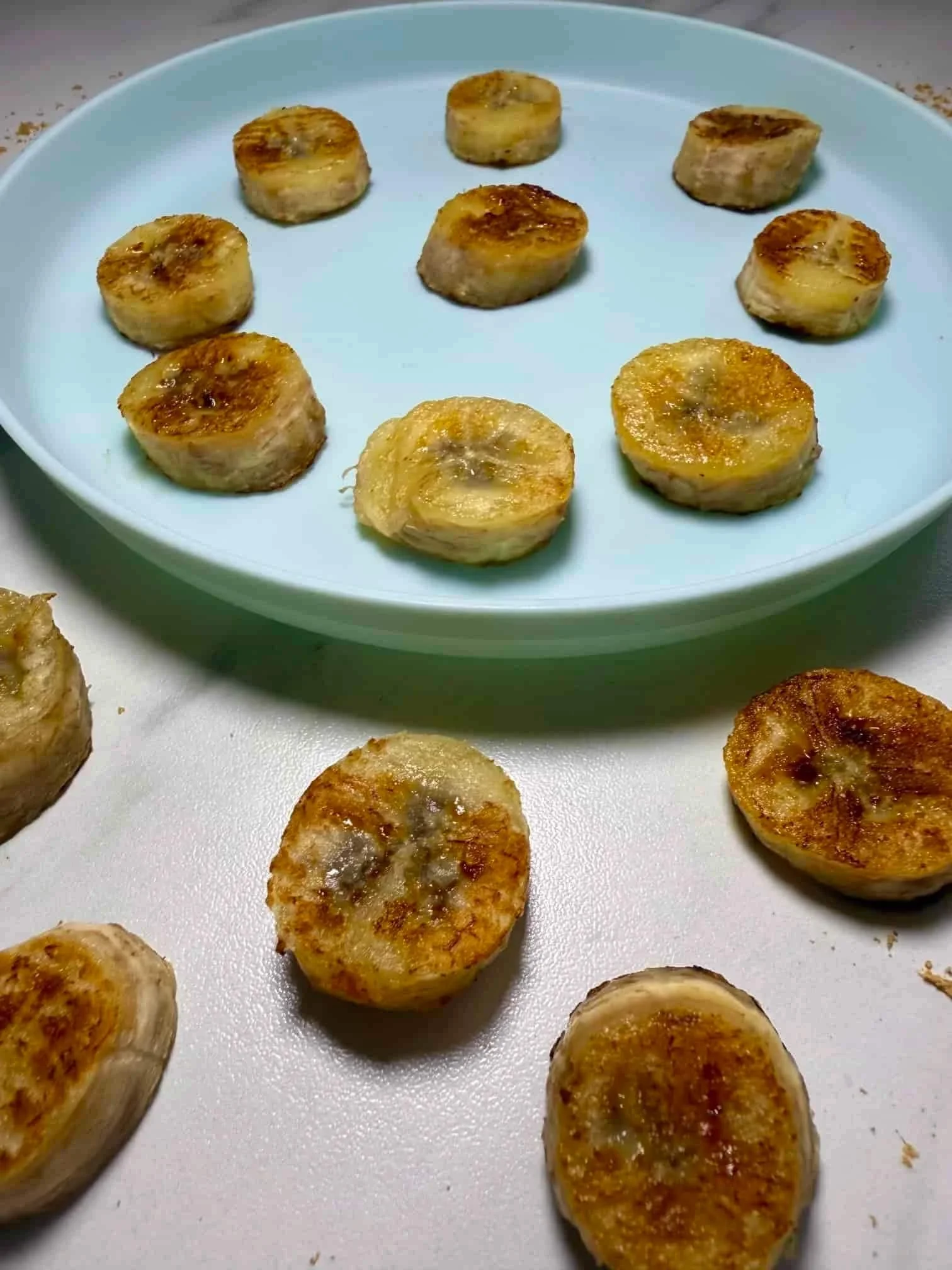 Slices of caramelized pan fried bananas served on toddler plate