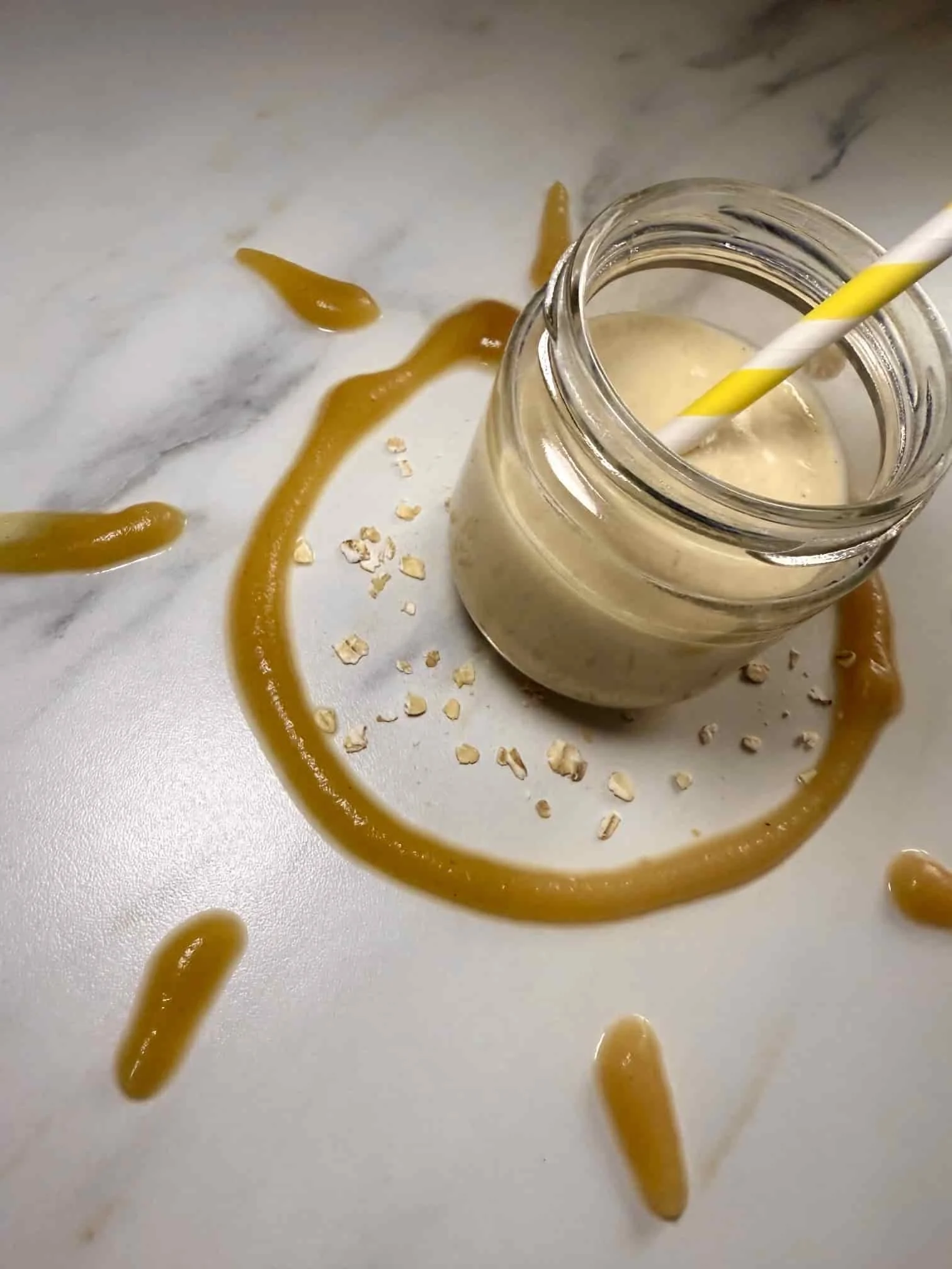 Apple and oat smoothie for baby and toddler served in a jar with a straw and pureed apple
