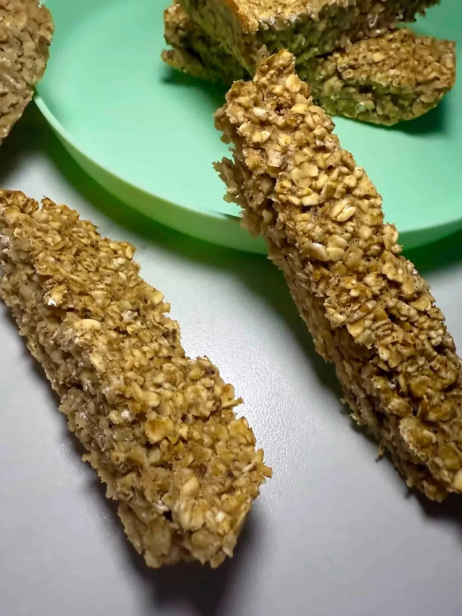 Several applesauce oatmeal bars arranged on and over a toddler plate