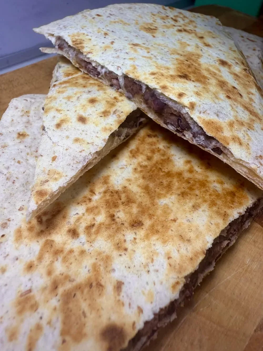Cooked veggie quesadilla cut into triangles and served on board