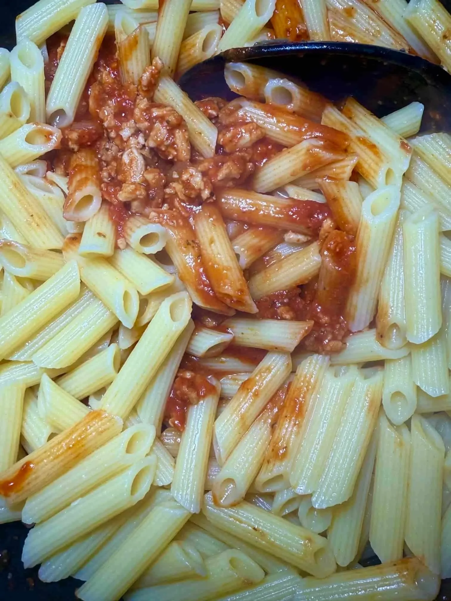 A portion of chicken mince penne pasta served in a toddler dish