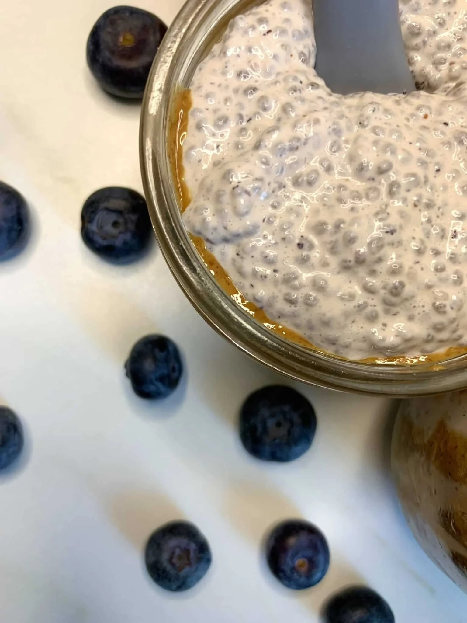 Chia seed pudding served in a small jar with blueberries on the side