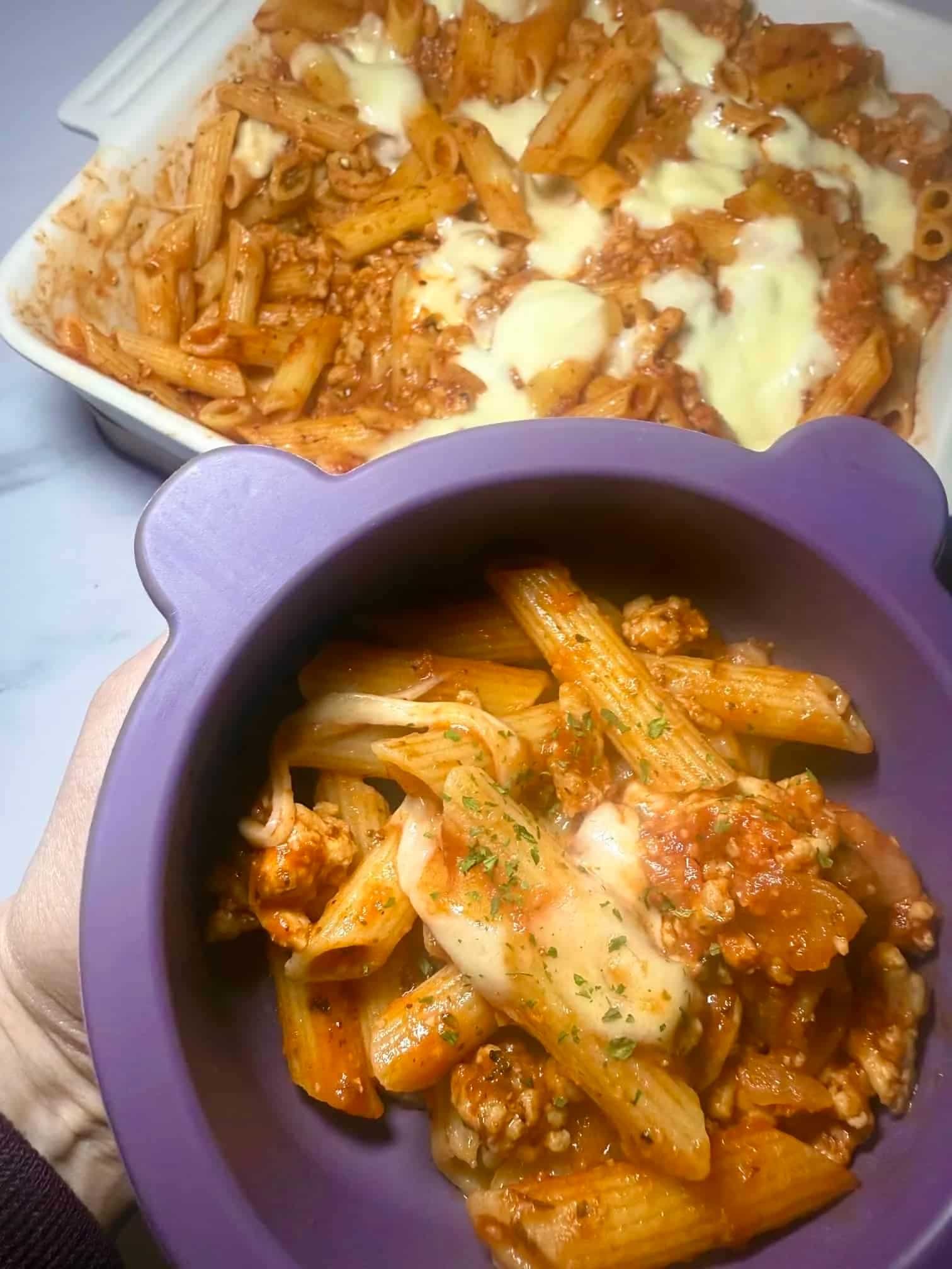 A portion of chicken mince pasta served from the main dish into a toddler dish