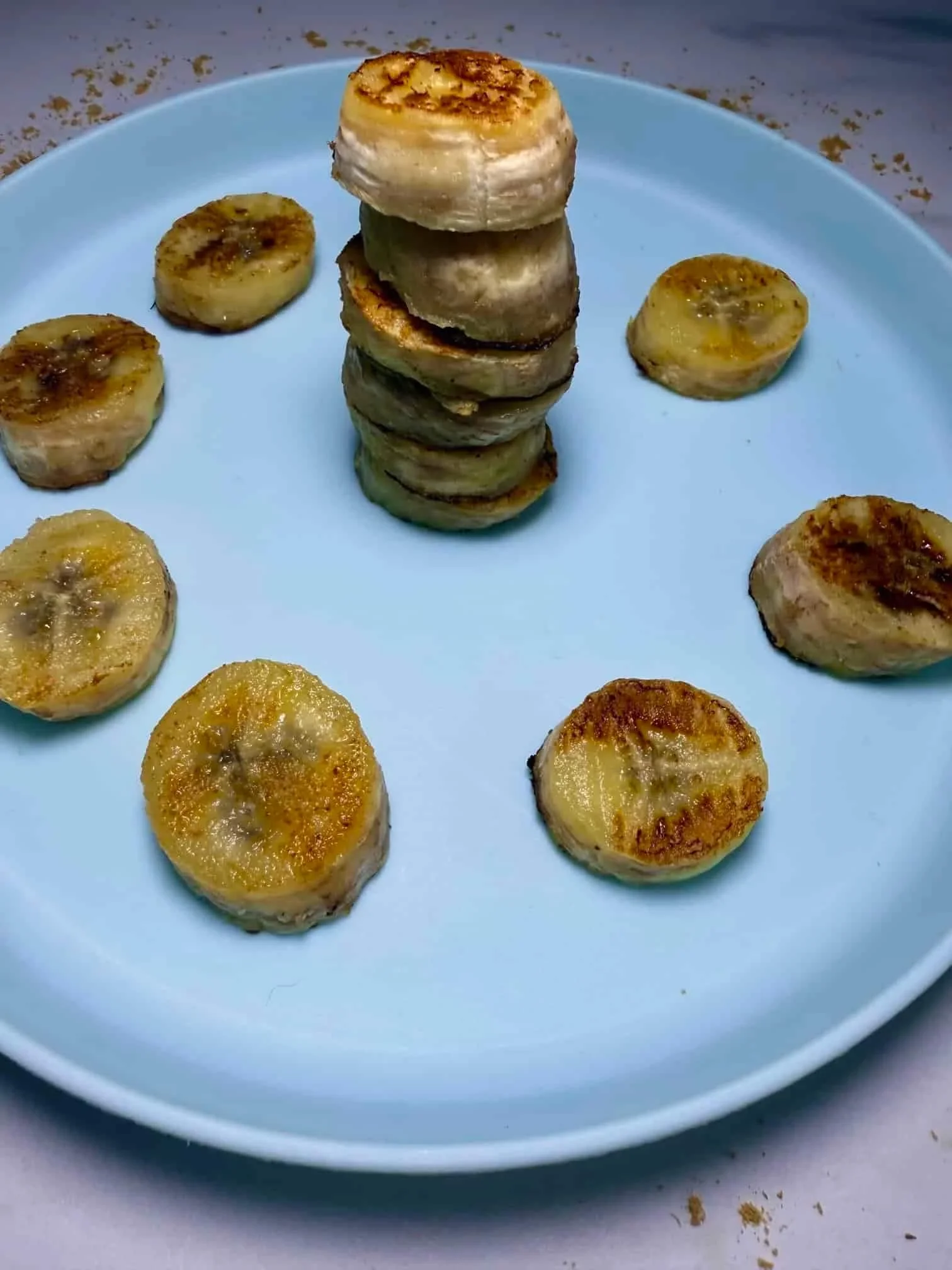 A stack and slices of caramelized pan fried bananas served on toddler plate