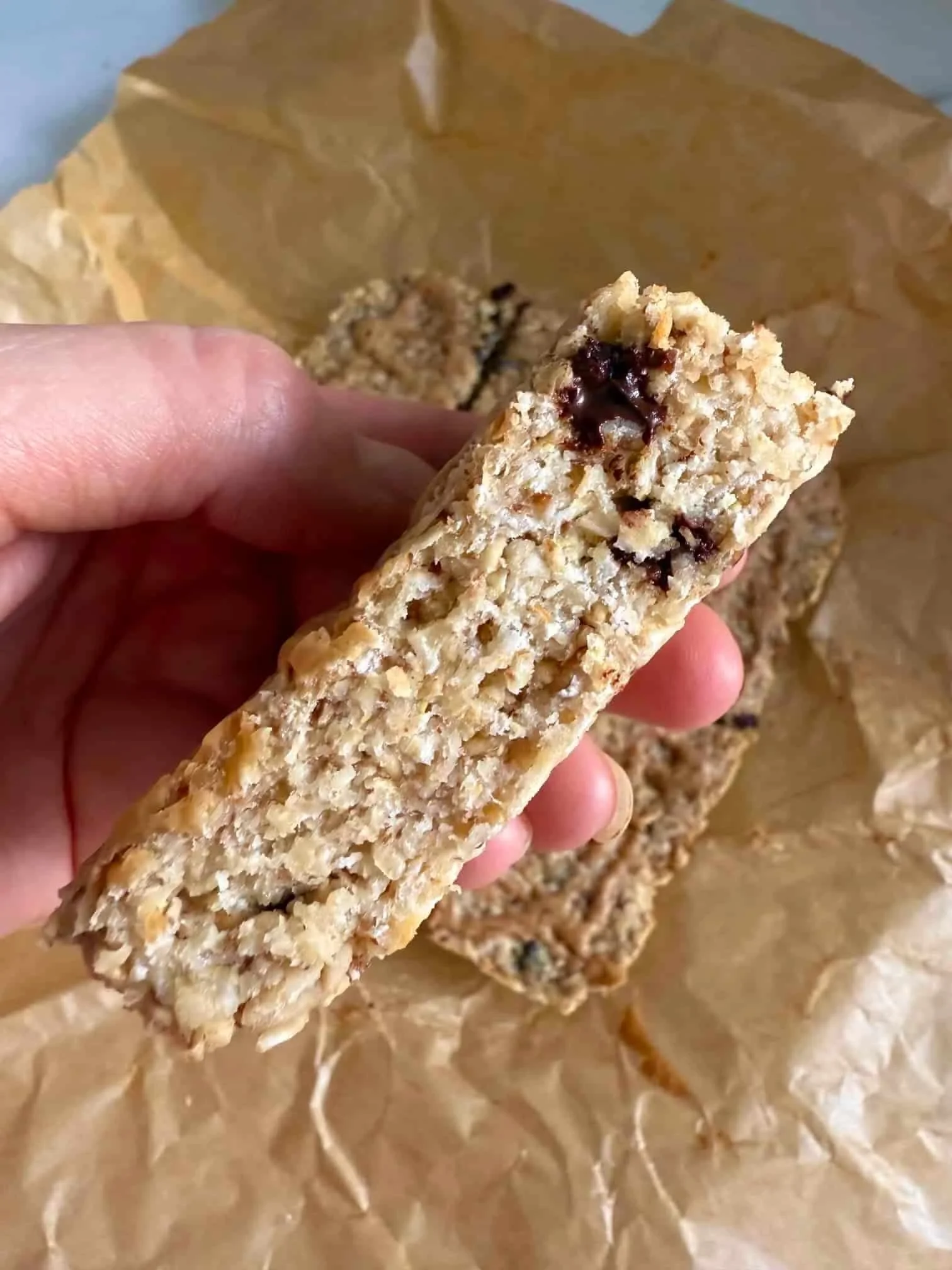 Close up image of a chocolate chip flapjack to show interior oaty texture