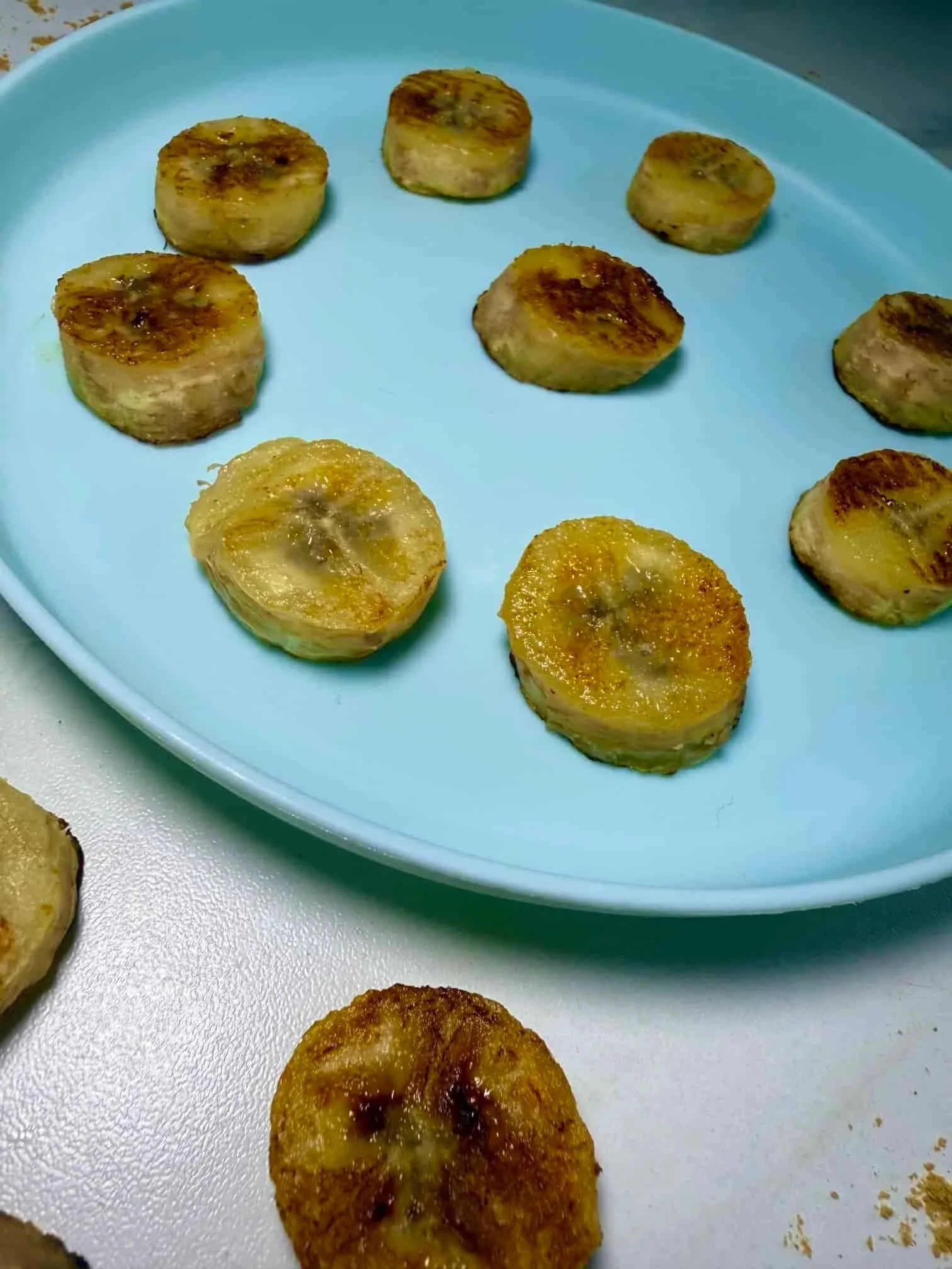 Slices of caramelized pan fried bananas served on toddler plate