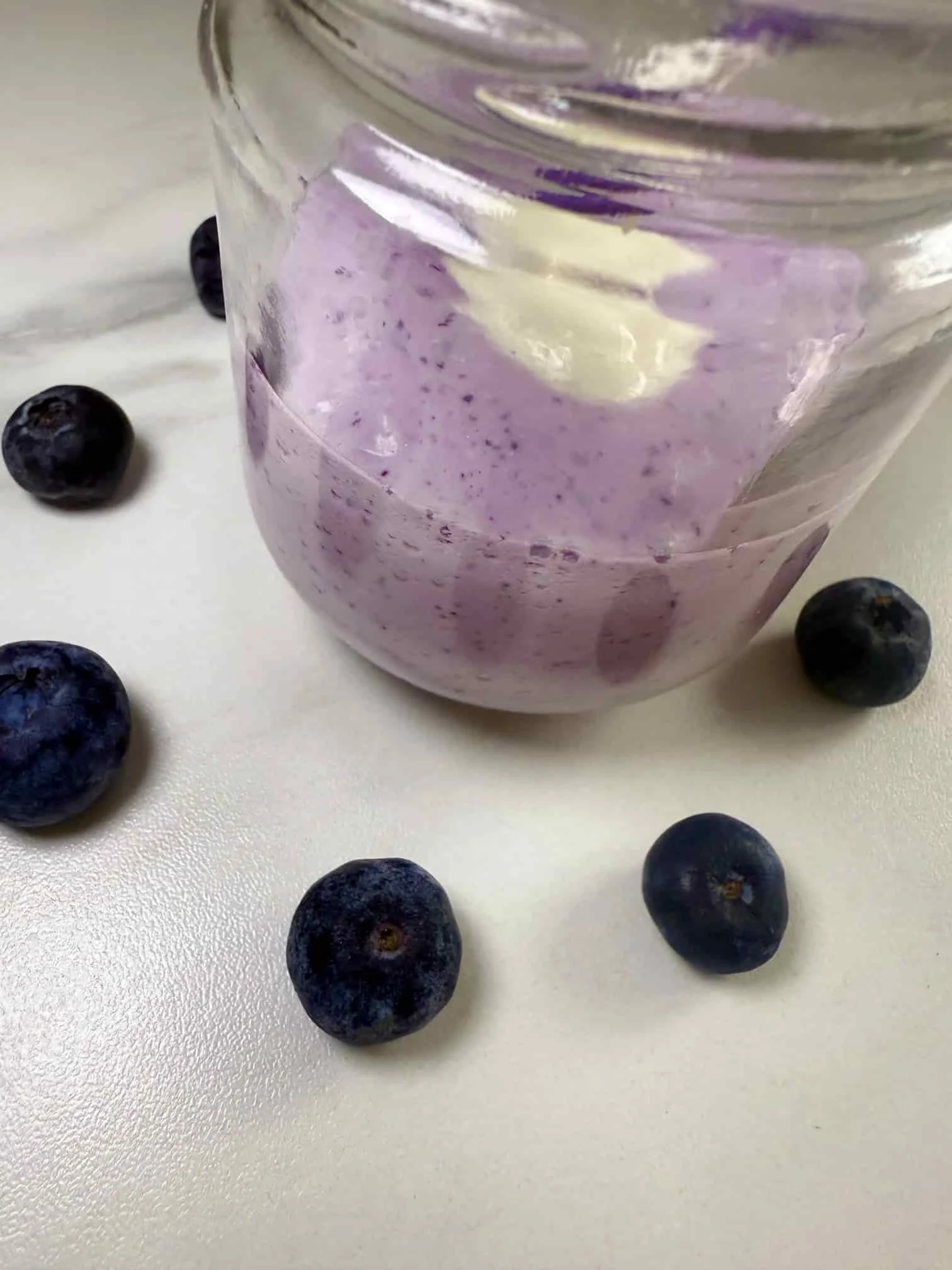 Cottage cheese fruit smoothie with blueberries and topped with Greek yogurt served in a mini Kilner jar with a straw