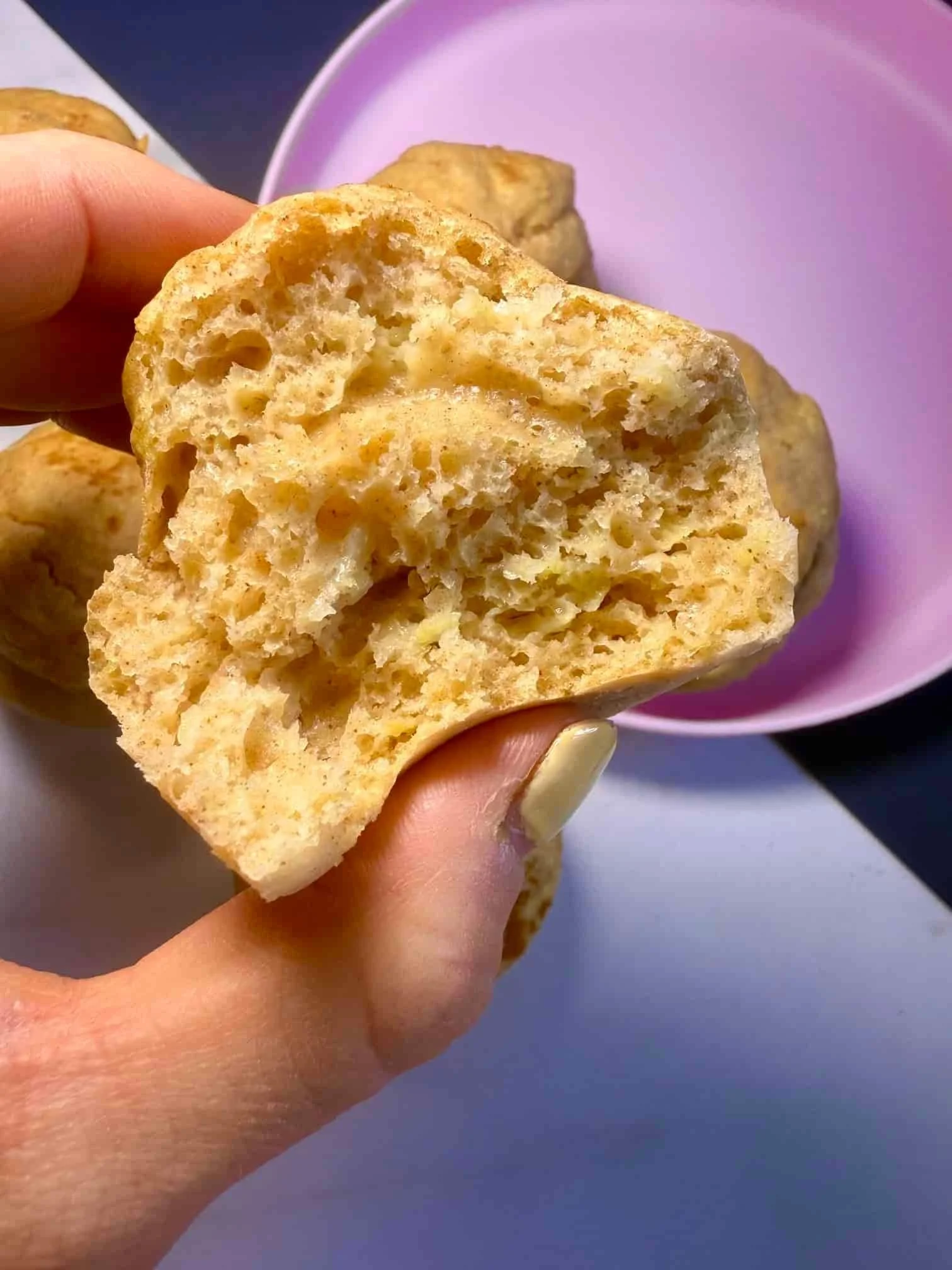 A close up image of a cooked apple muffin that has been cut in half
