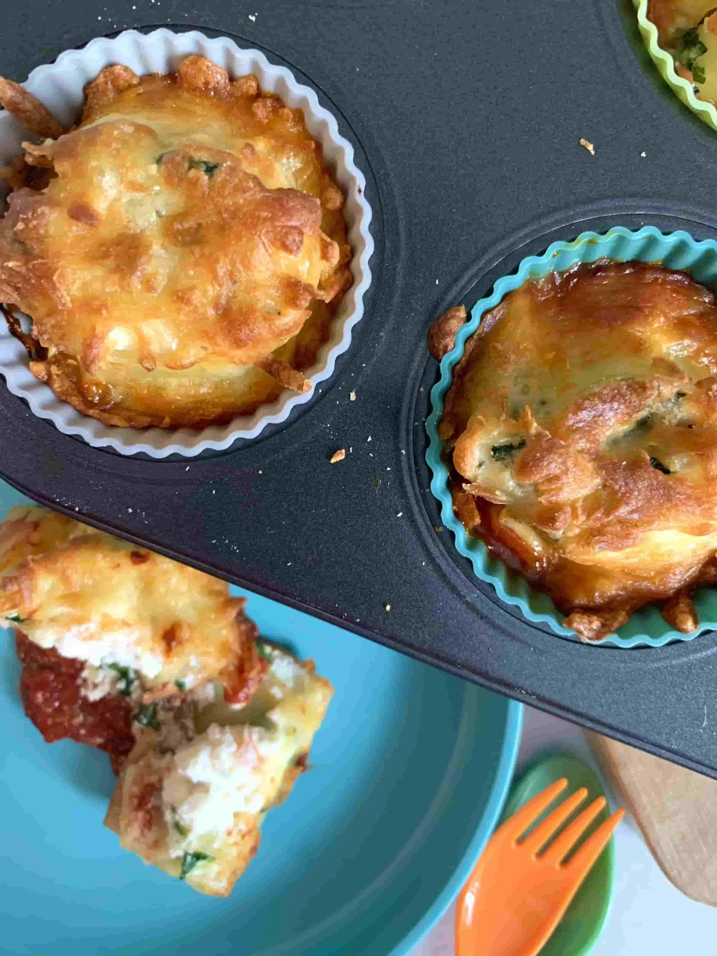 Overhead view of spinach and ricotta lasagne roll ups in muffin cases