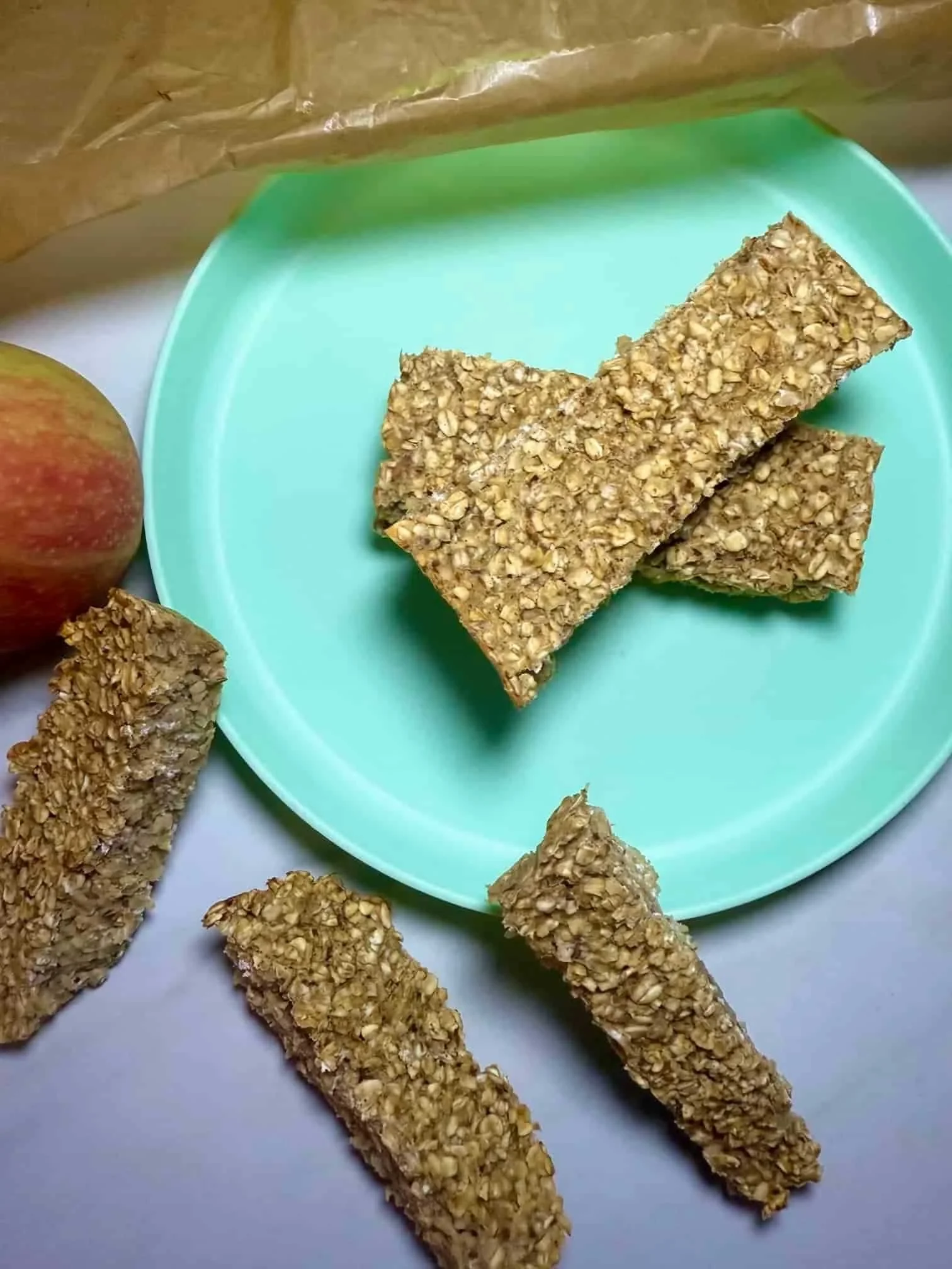 Several baked applesauce oatmeal bars arranged on and over a toddler plate