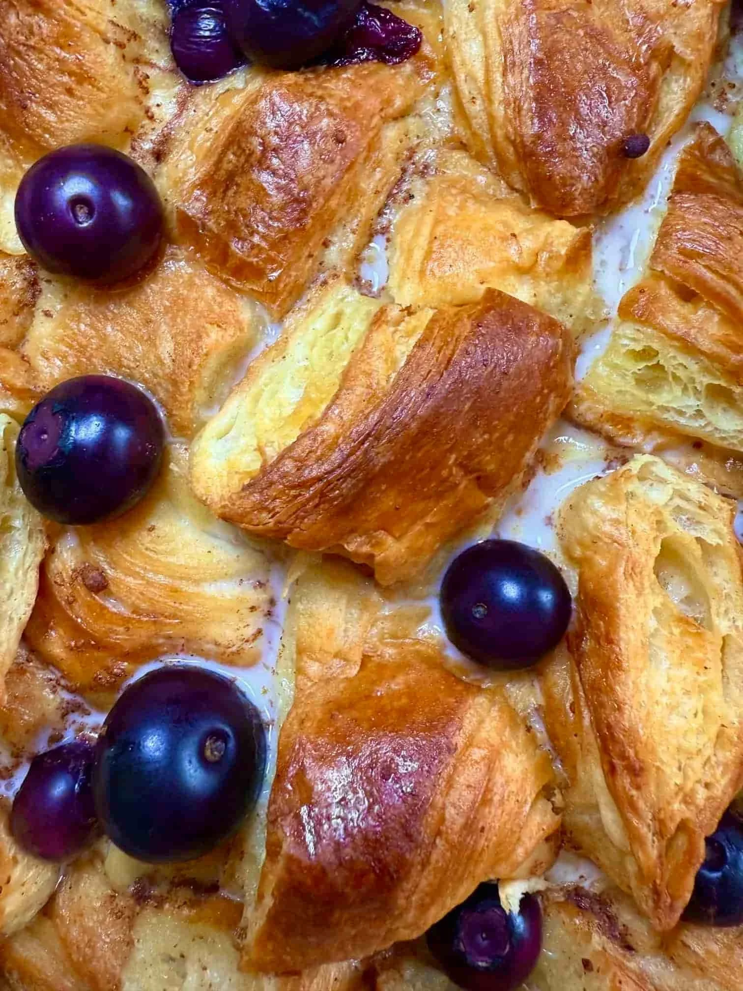 Close up image of a cooked slice of blueberry croissant breakfast bake