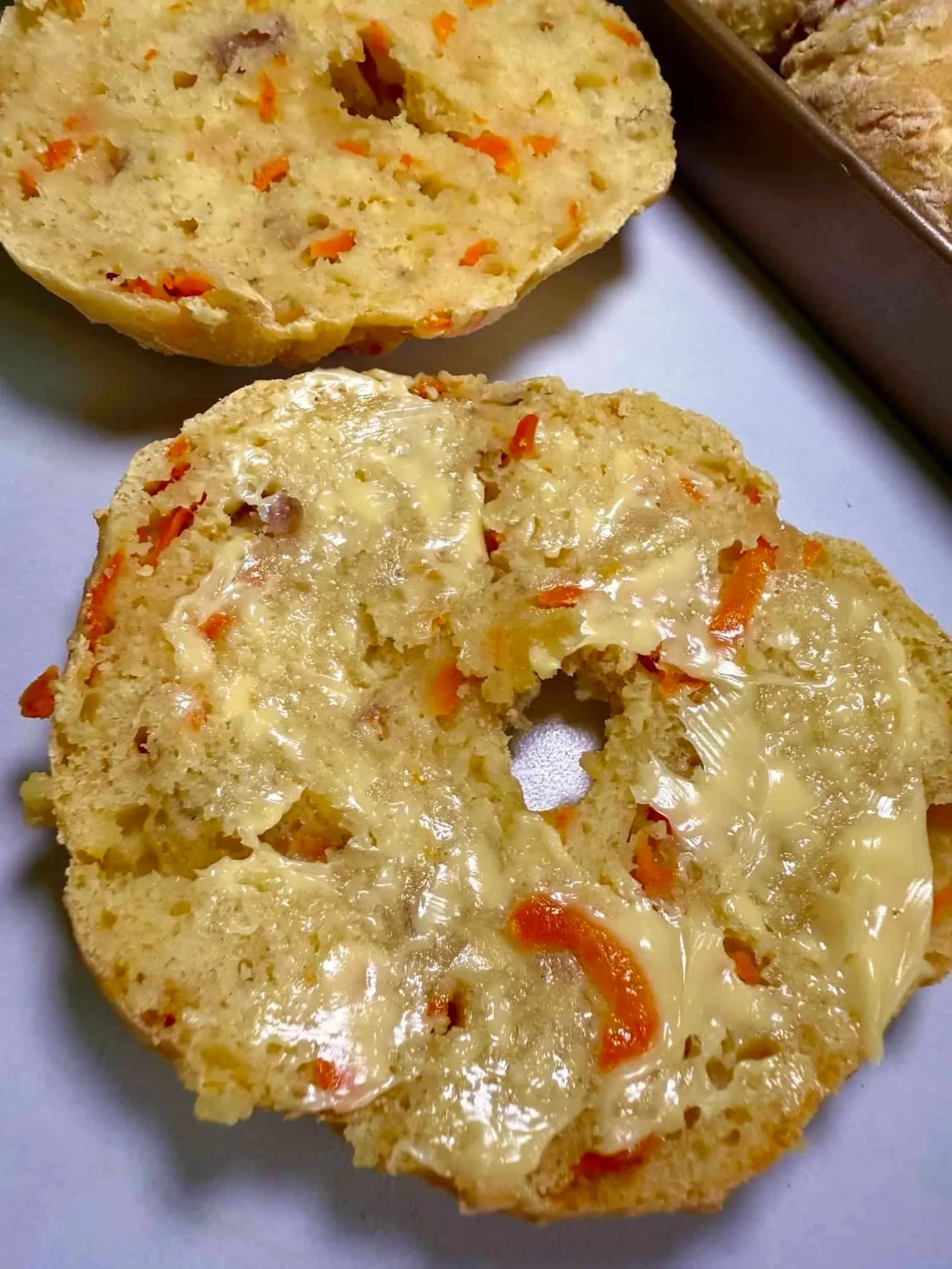A baked ABC bagel cut in half and spread with butter