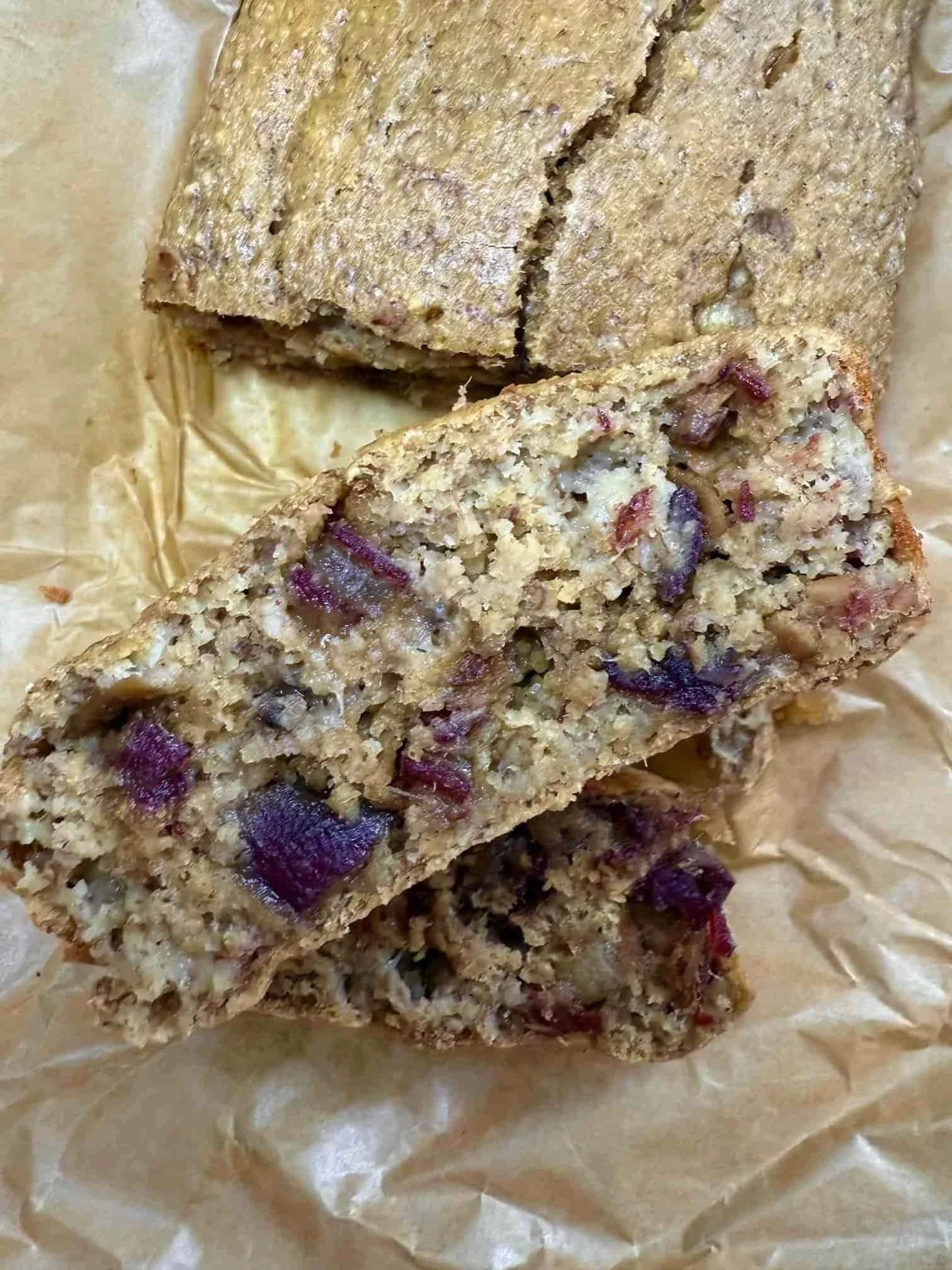 Two pieces of cooked date and banana loaf sliced from the main cake