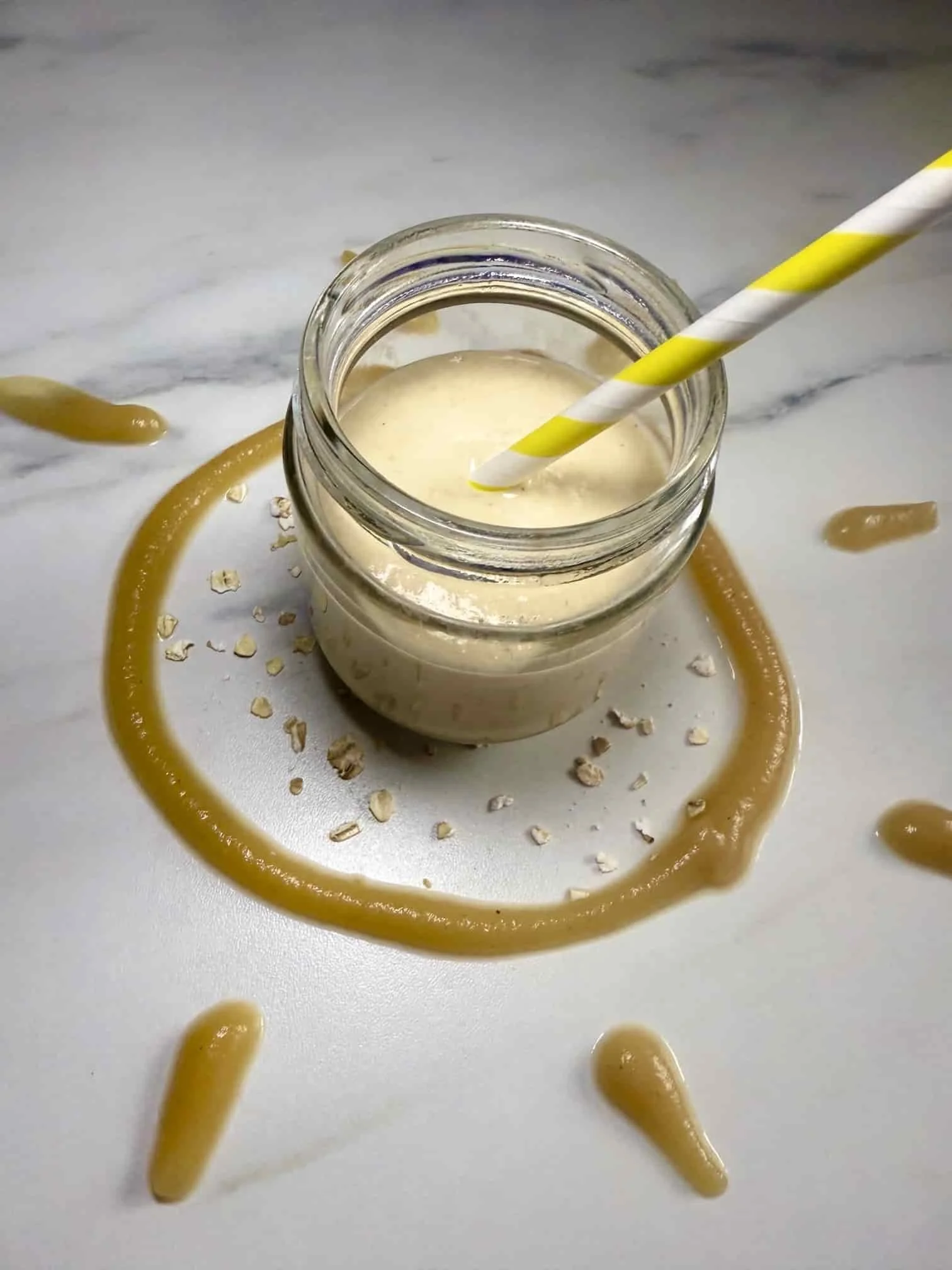 Apple and oat smoothie for baby and toddler served in a jar with a straw and pureed apple