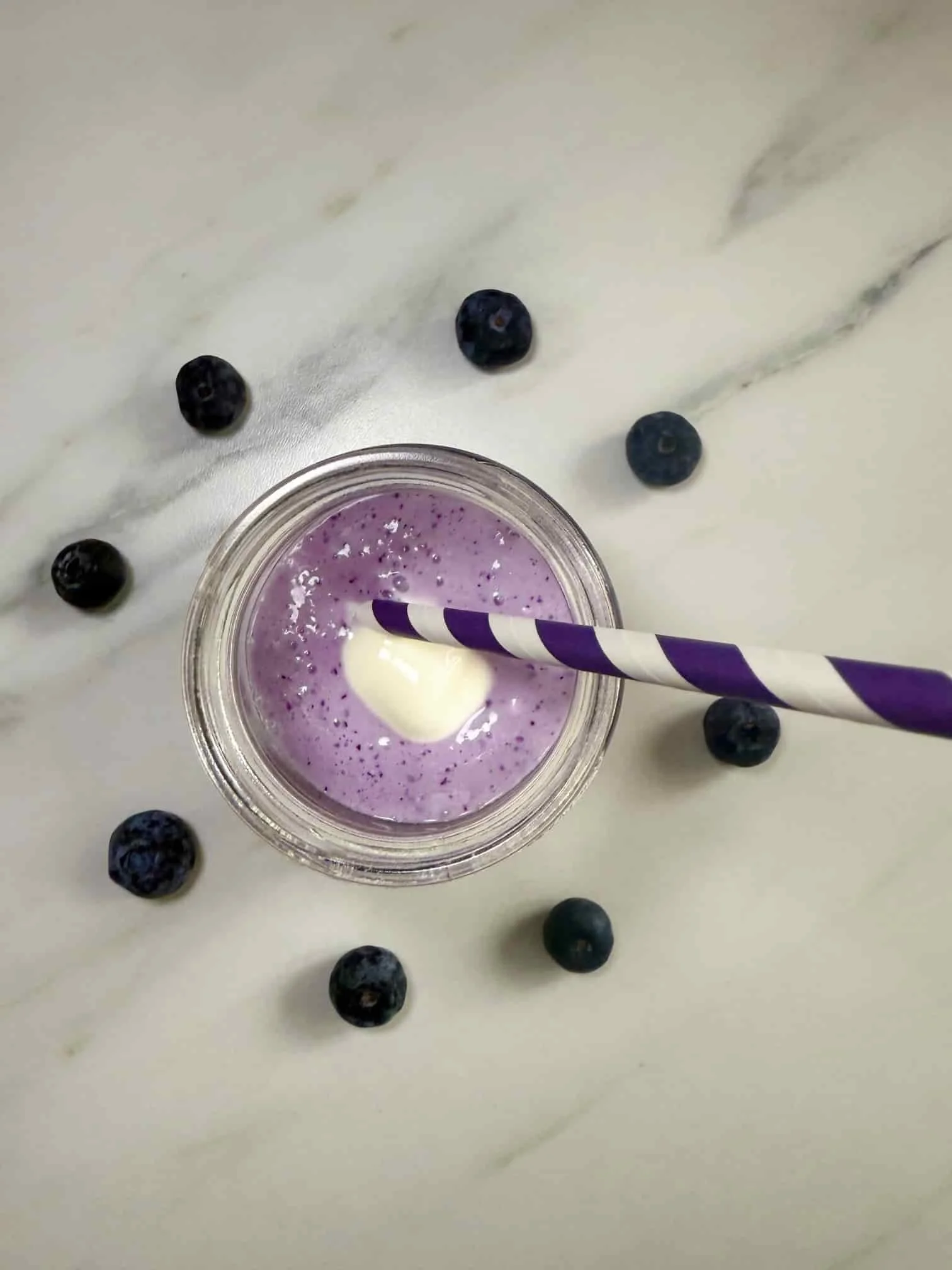 Cottage cheese fruit smoothie with blueberries and topped with Greek yogurt served in a mini Kilner jar with a straw