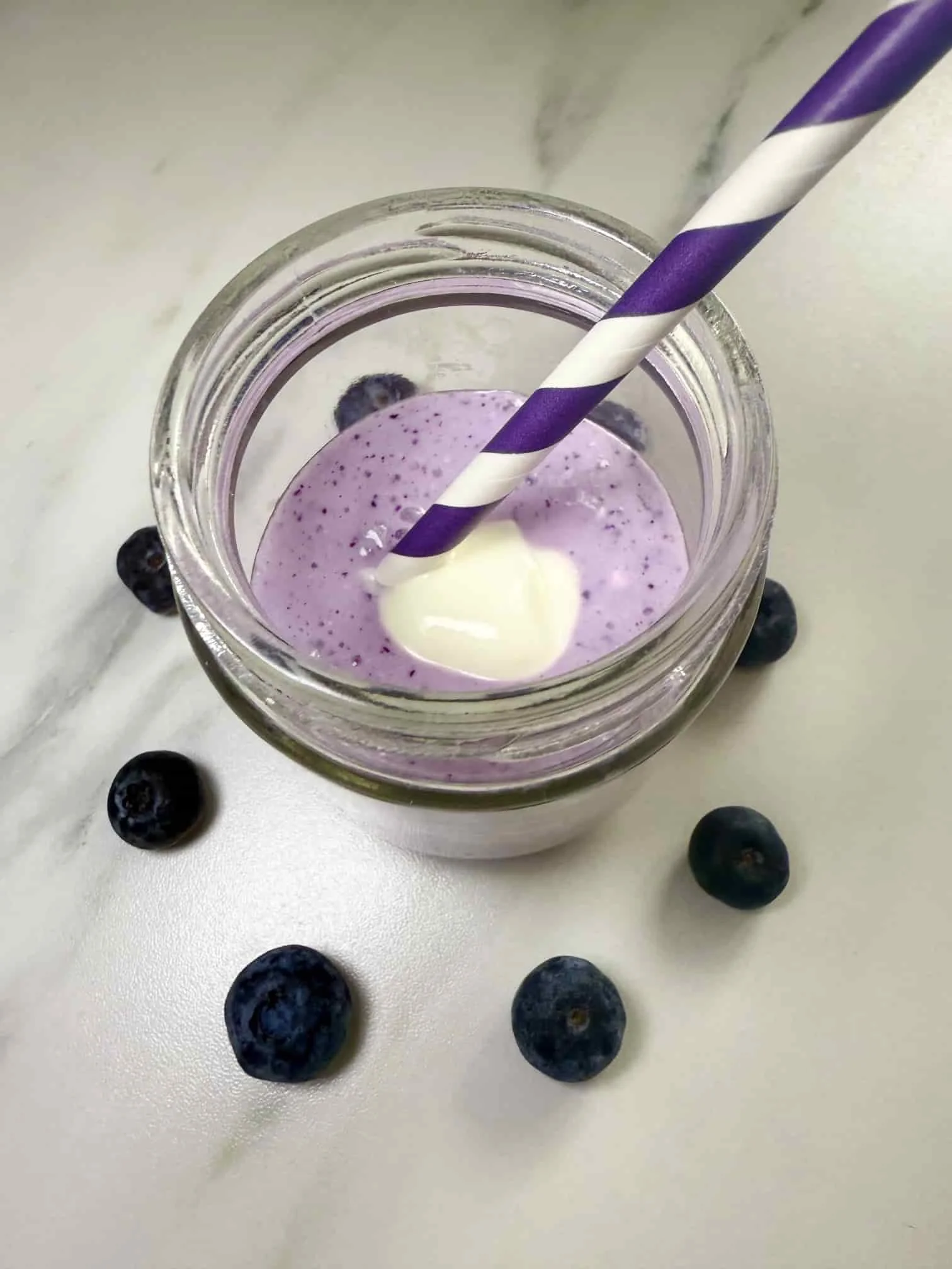 Cottage cheese fruit smoothie with blueberries and topped with Greek yogurt served in a mini Kilner jar with a straw