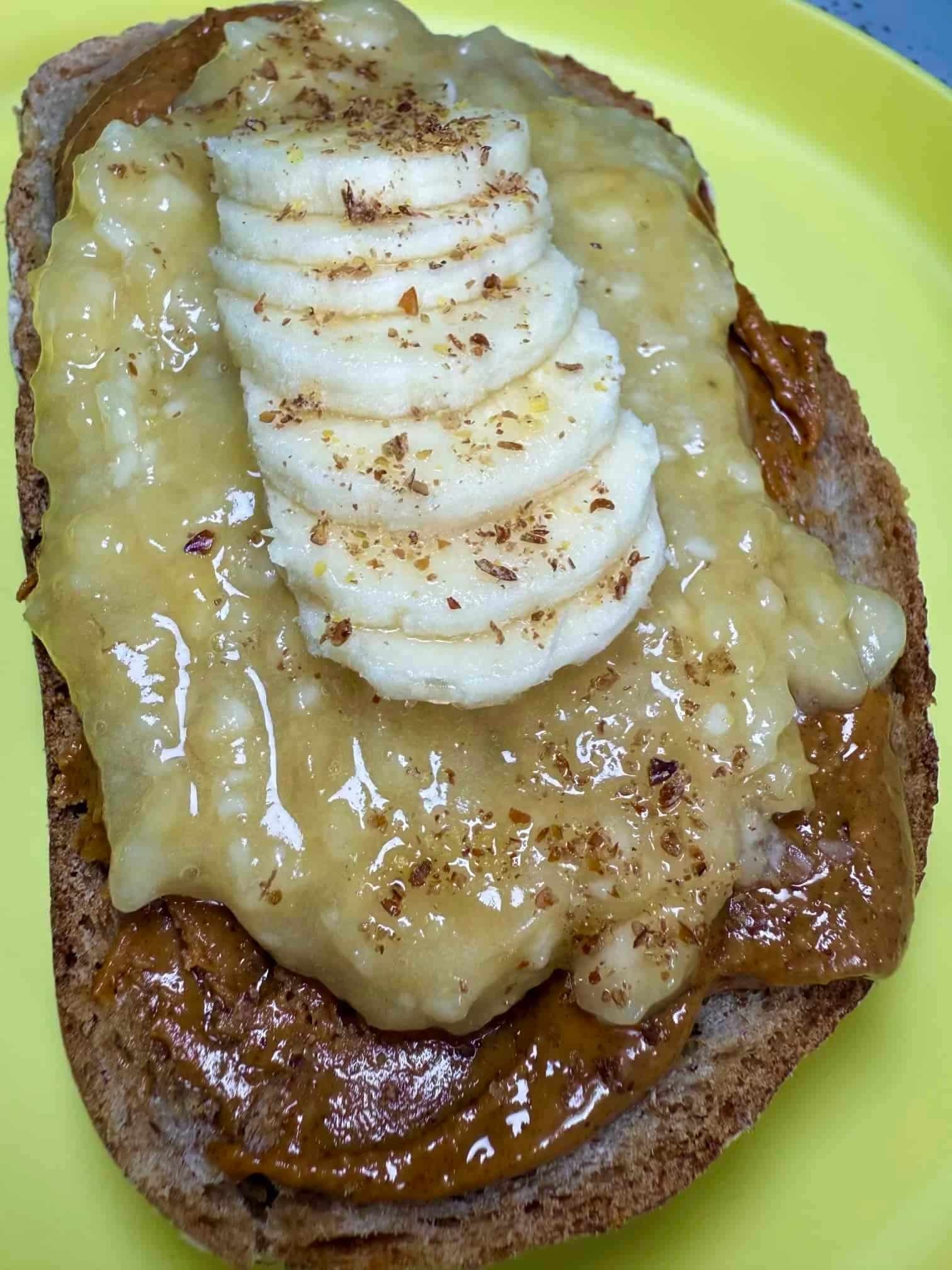A slice of toast layered with peanut butter, pureed and sliced banana and sprinkled with flaxseed