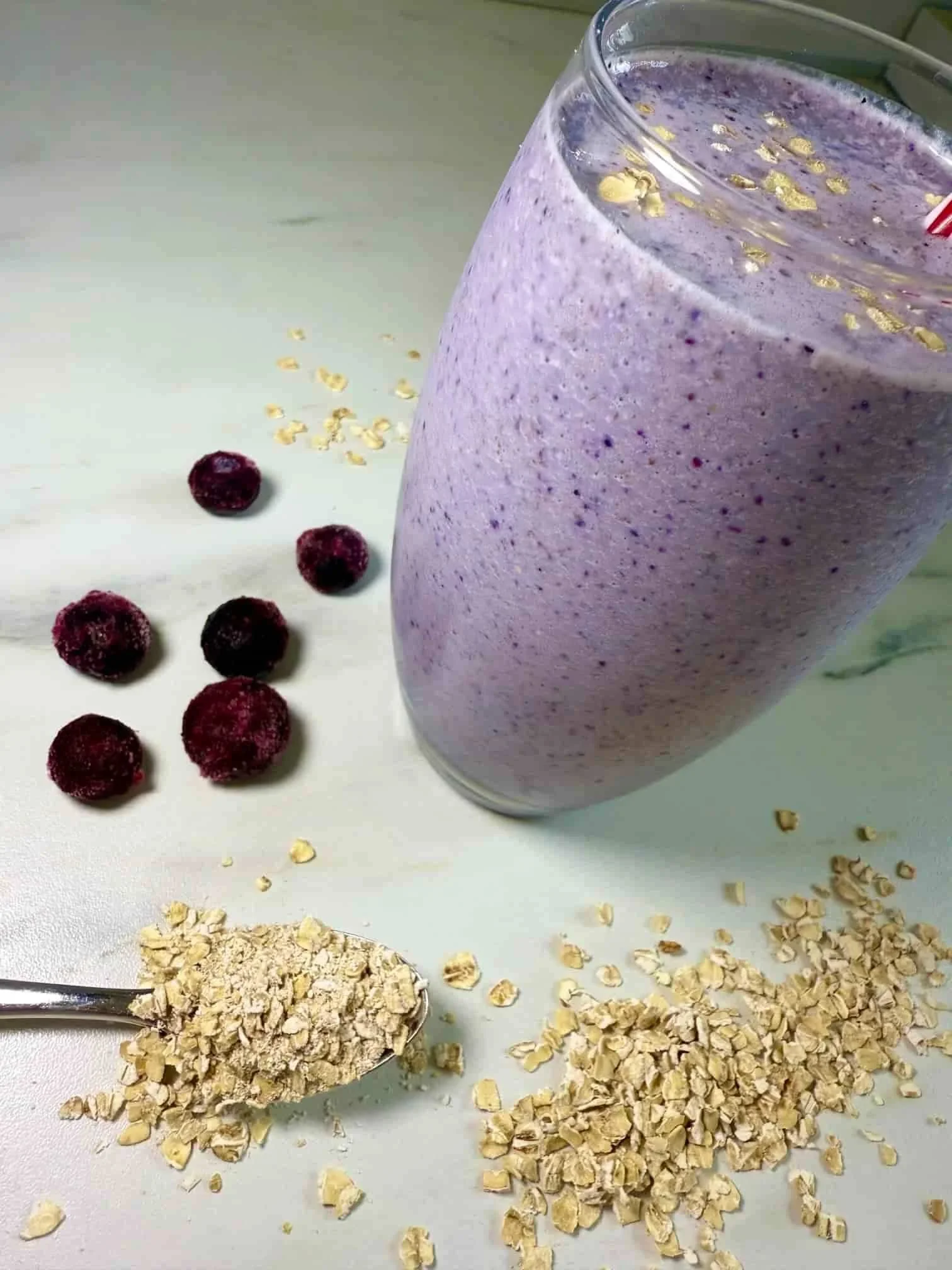 A glass of the lactation smoothie with blueberries and oats