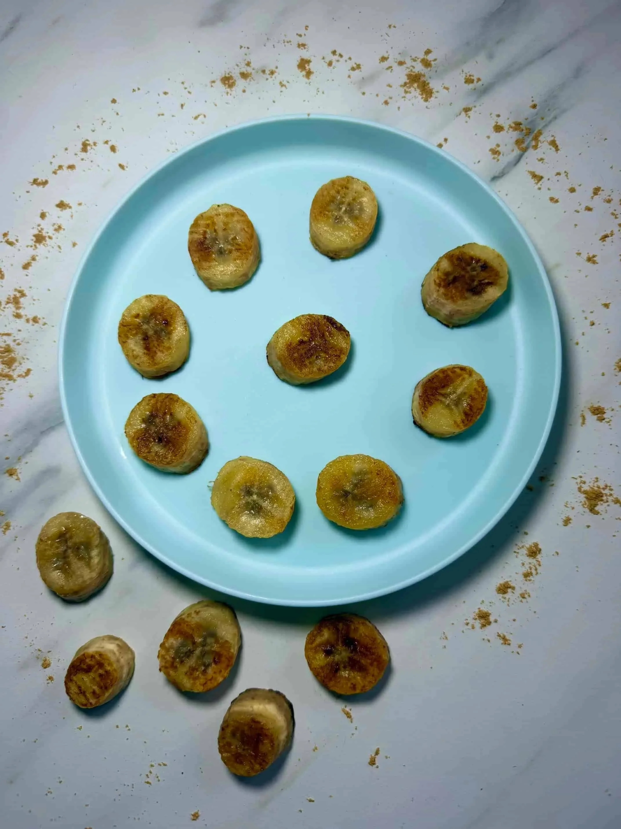 Slices of caramelized pan fried bananas served on toddler plate