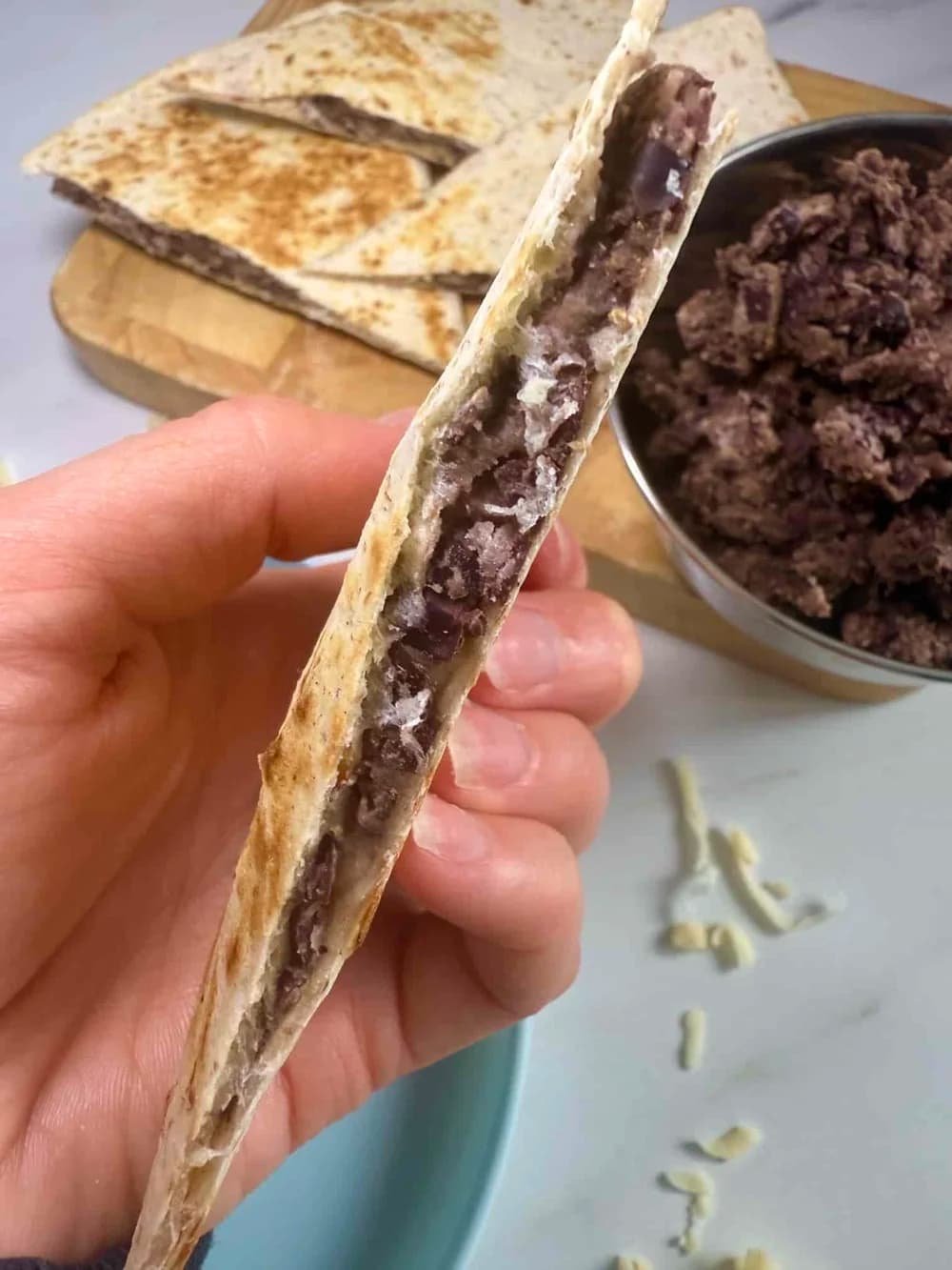 Cooked veggie quesadilla cut into triangles and served on board