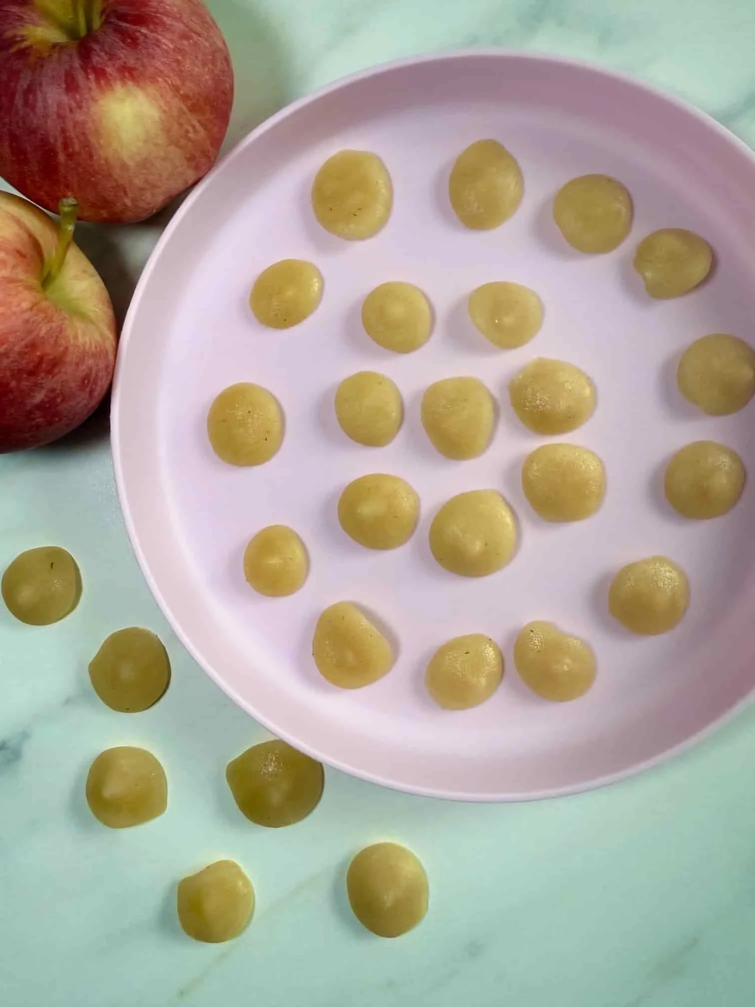 Several bite sized portions of applesauce on serving dish ready for the freezer