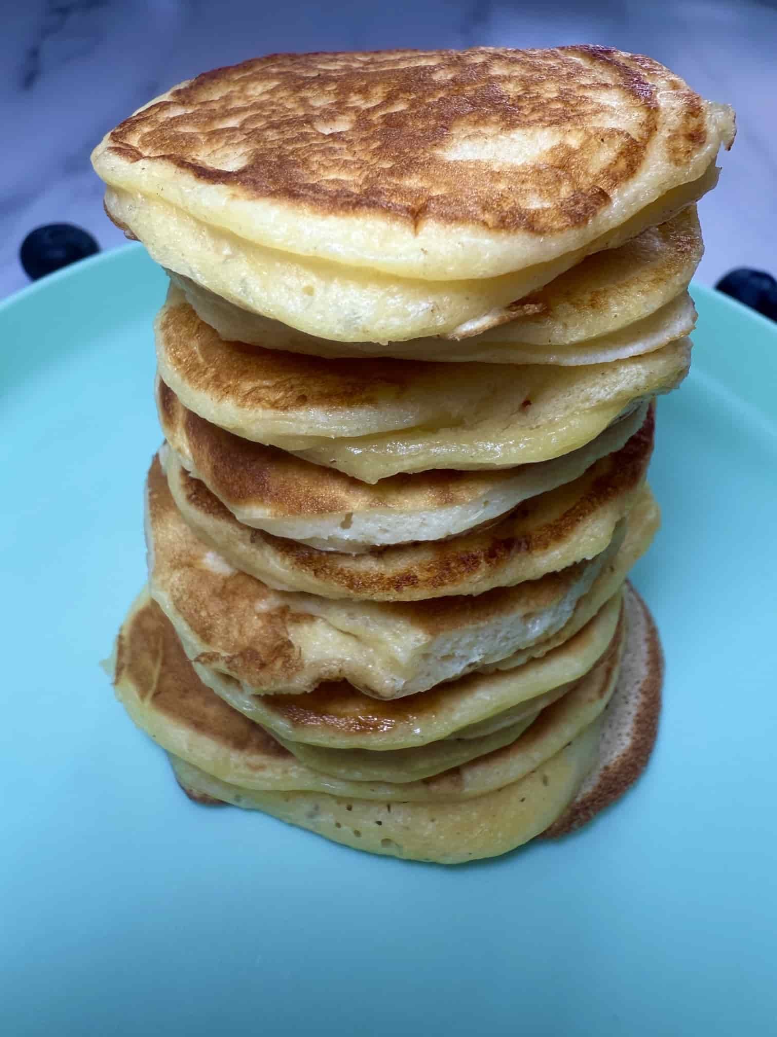 A stack of cooked Greek yogurt pancakes using only 3 ingredients served on toddler plate