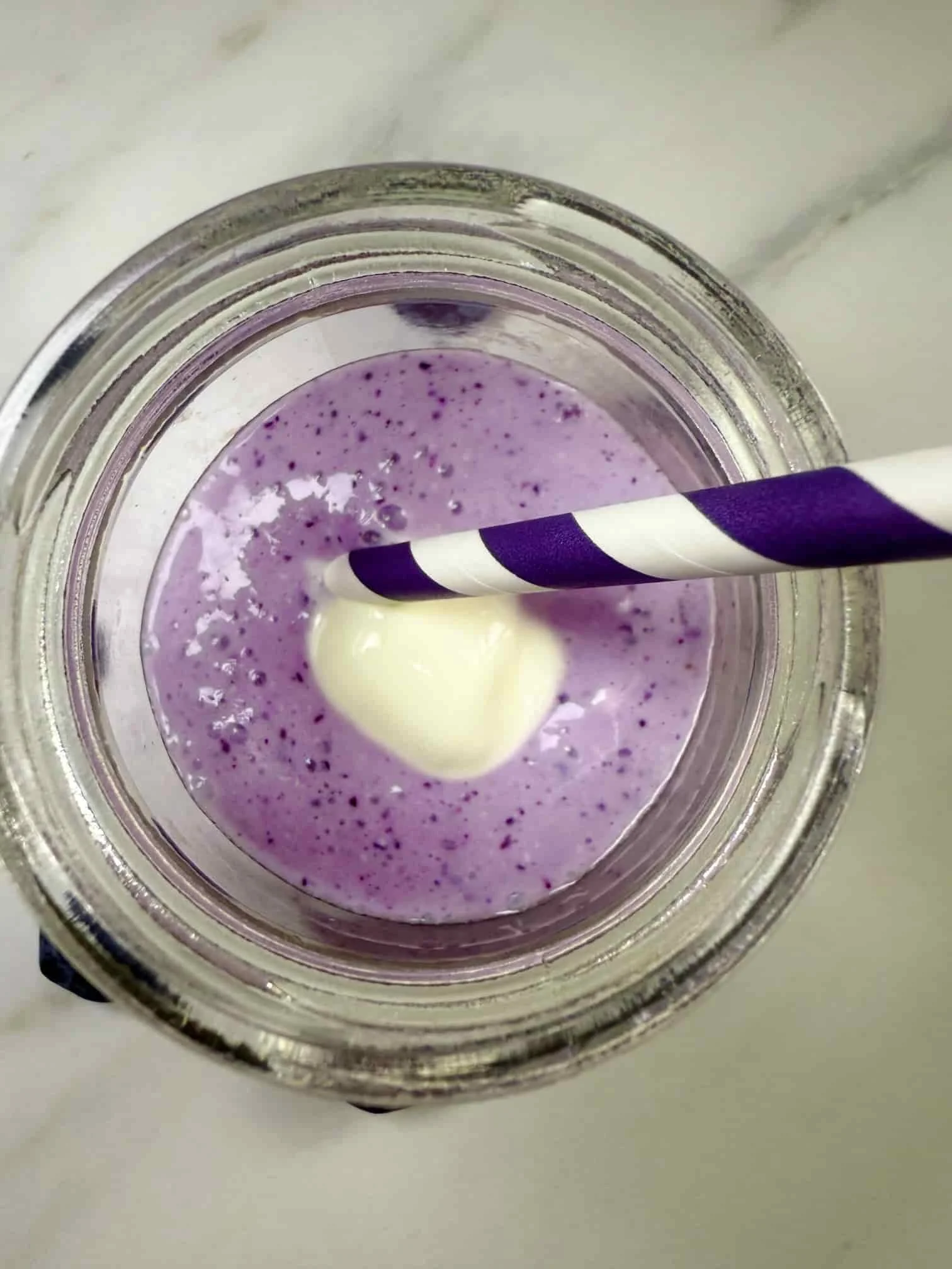 Cottage cheese fruit smoothie with blueberries and topped with Greek yogurt served in a mini Kilner jar with a straw