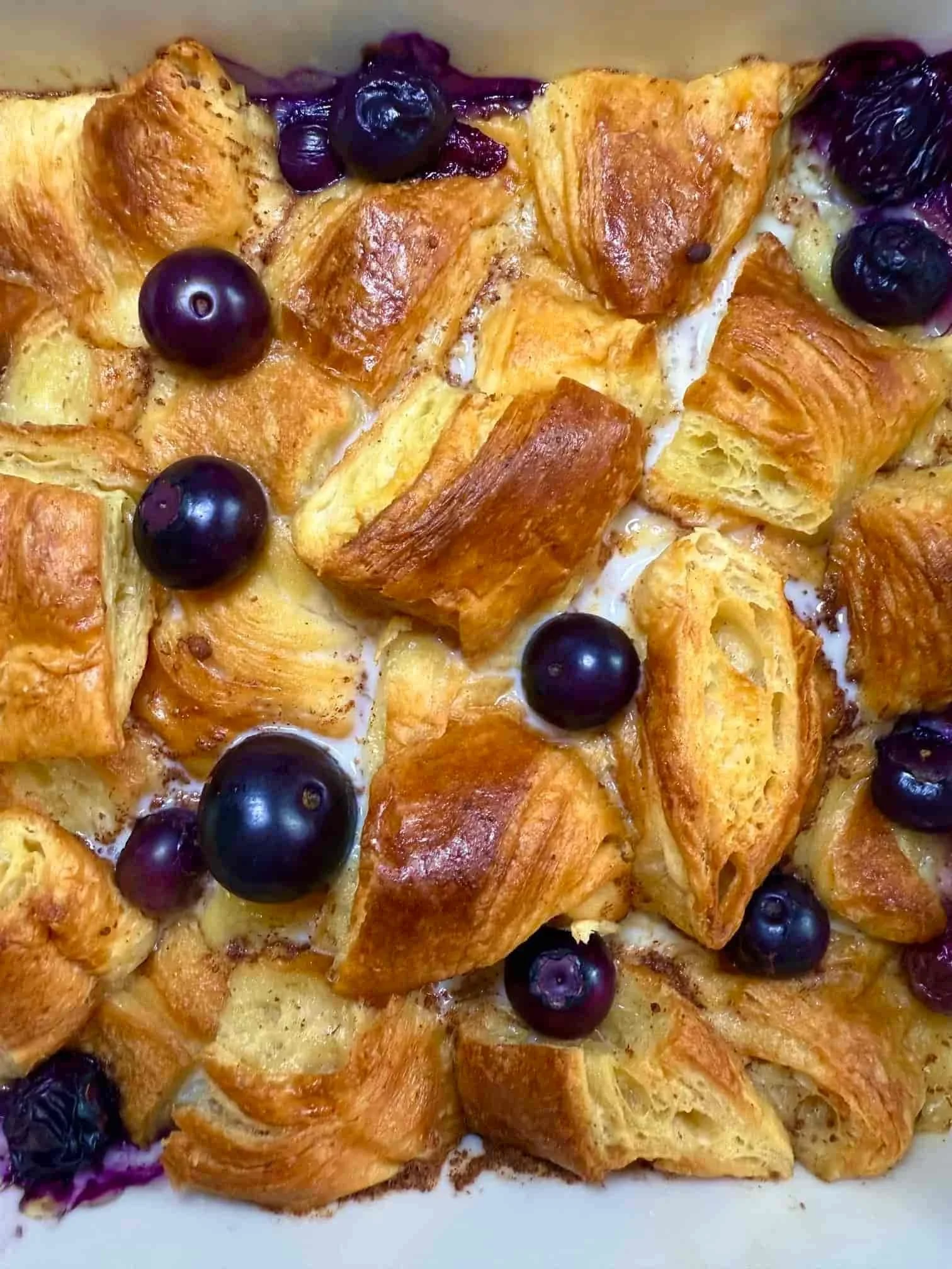 Close up image of a cooked blueberry croissant breakfast bake