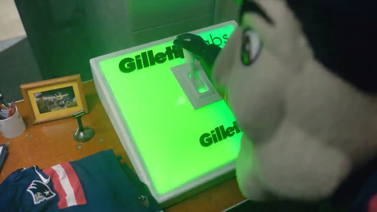 Gillette mascot and illuminated branded sign on a desk, created with Unreal Engine and Pixotope in a real-time virtual production pipeline.