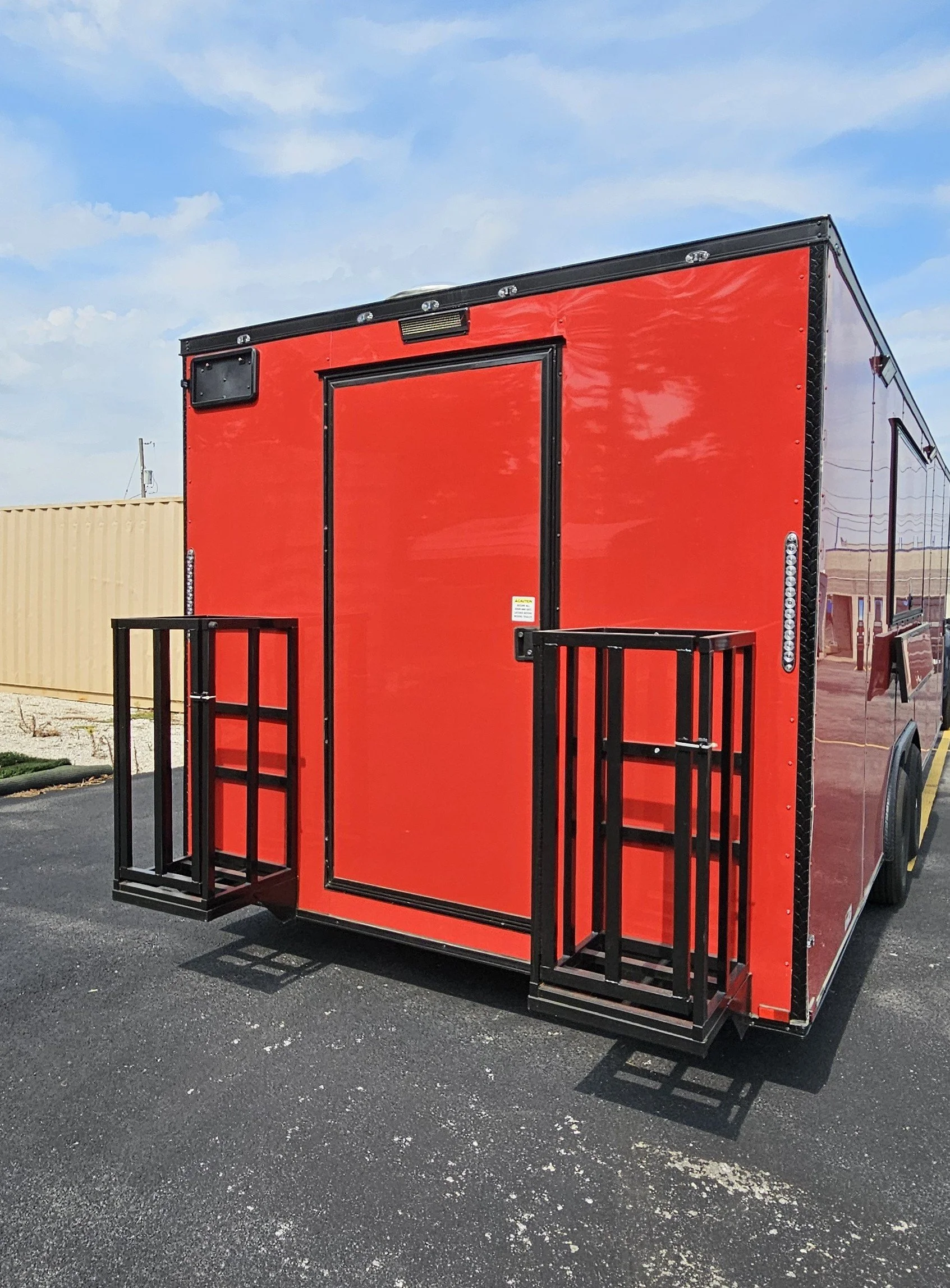 This concession trailer has a RV door in the back and two propane cages