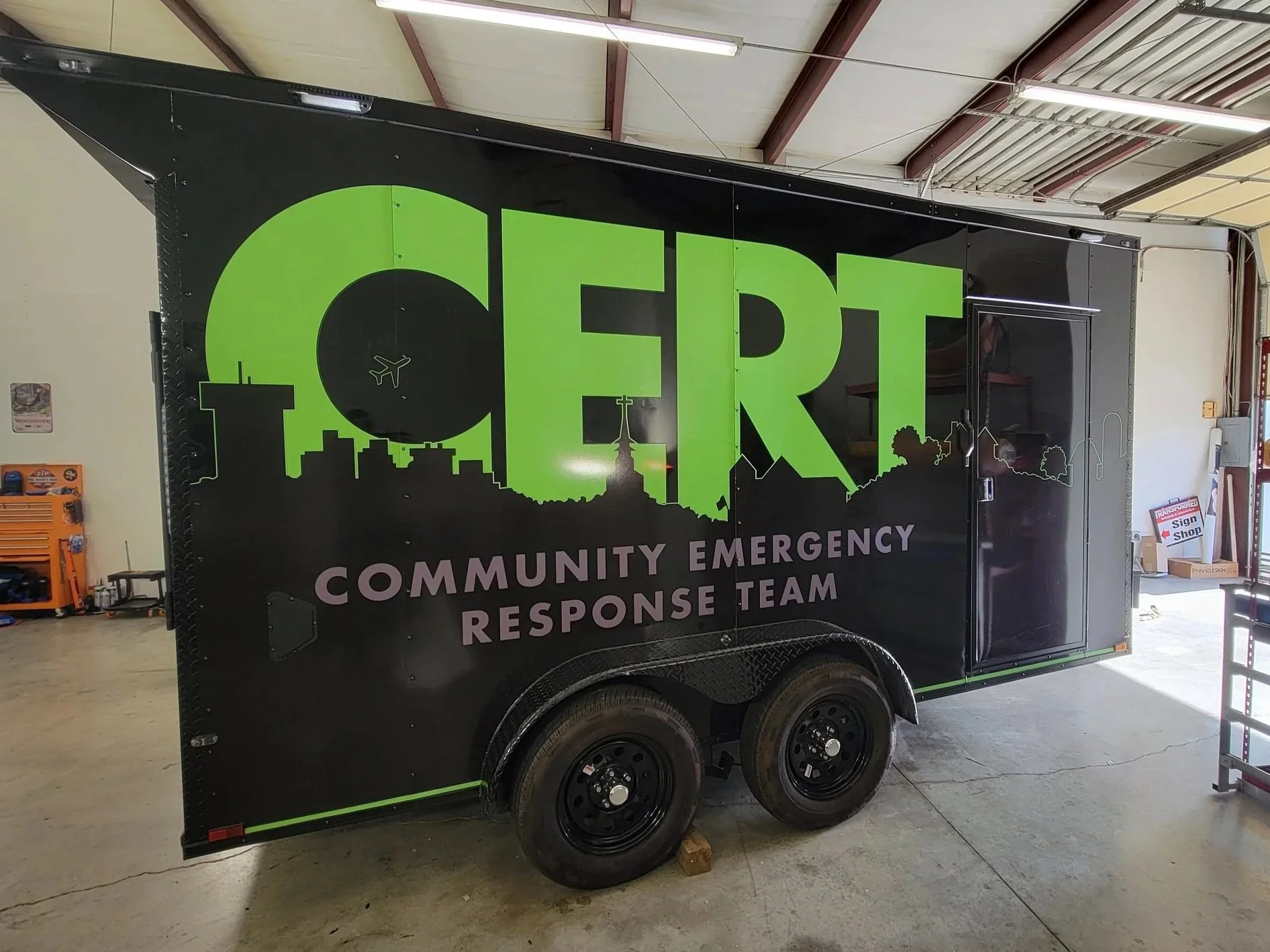 black cargo trailer with lime green CERT and grey text that reads Community Emergency Response Team