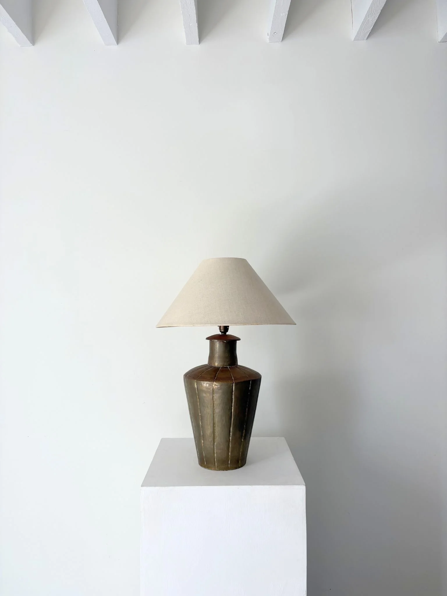 A charming Indian brass lamp with distinct vertical fluted panels tapering toward a narrow circular base - Bureau Bruton