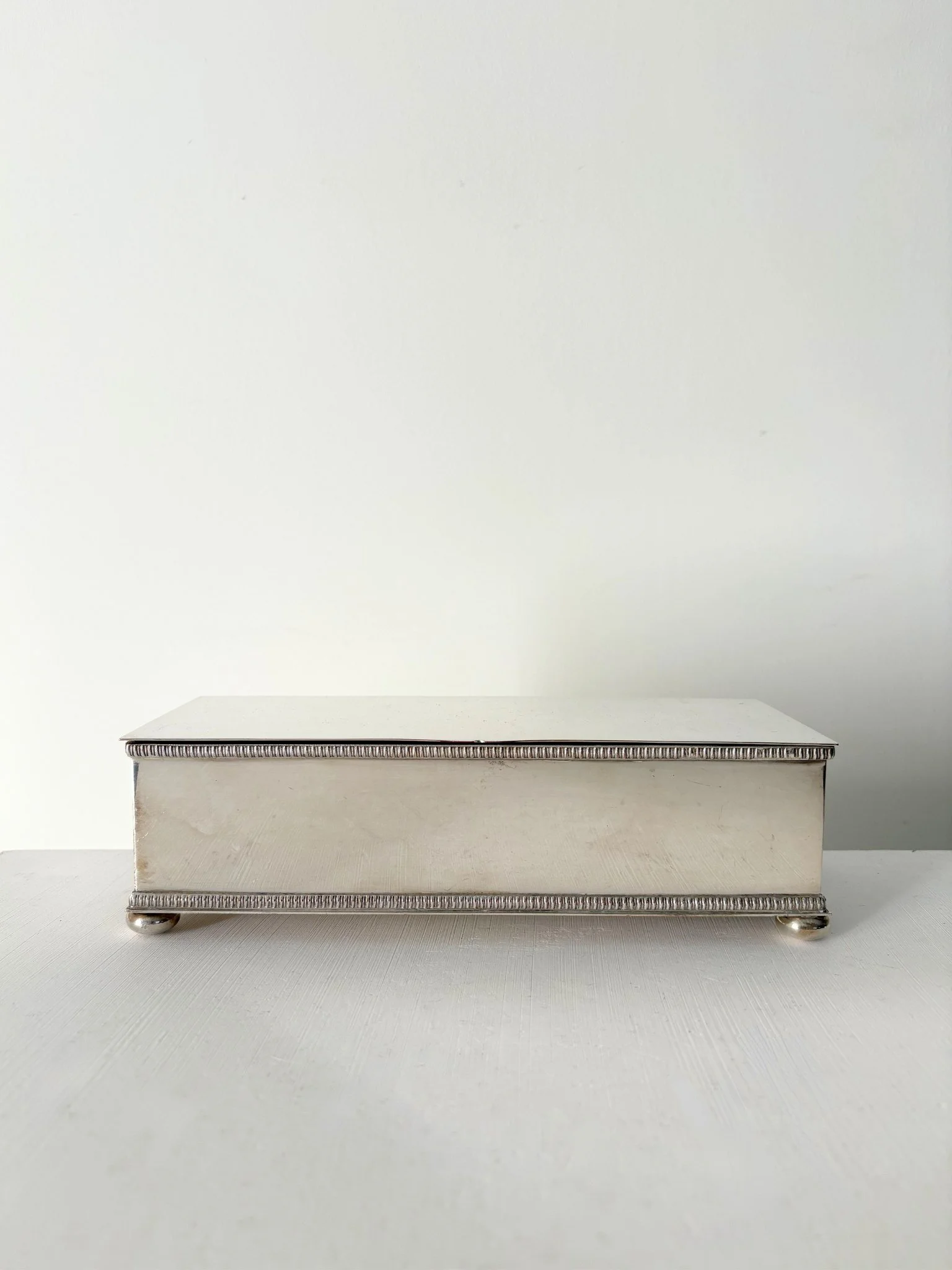 An early 20th Century antique silver plated trinket box, raised on four bun feet - Bureau Bruton