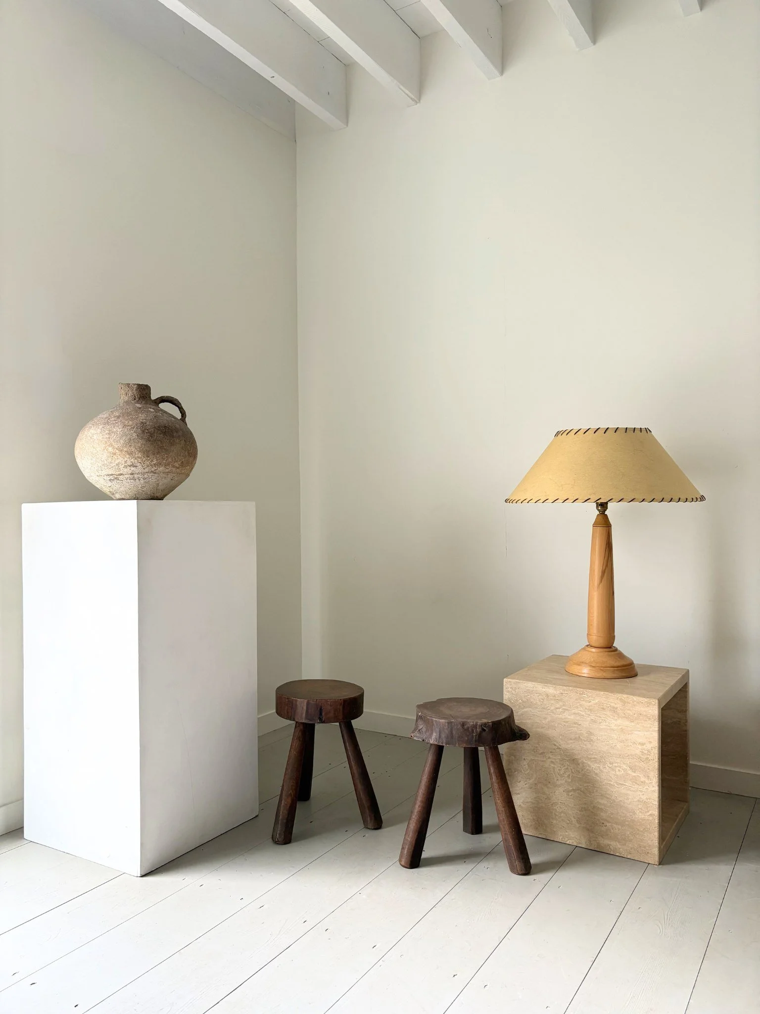 An ancient Middle Eastern Vessel sits next to a complementary pair of primitive tree slab stools from France - Bureau Bruton Design and Antique Shop