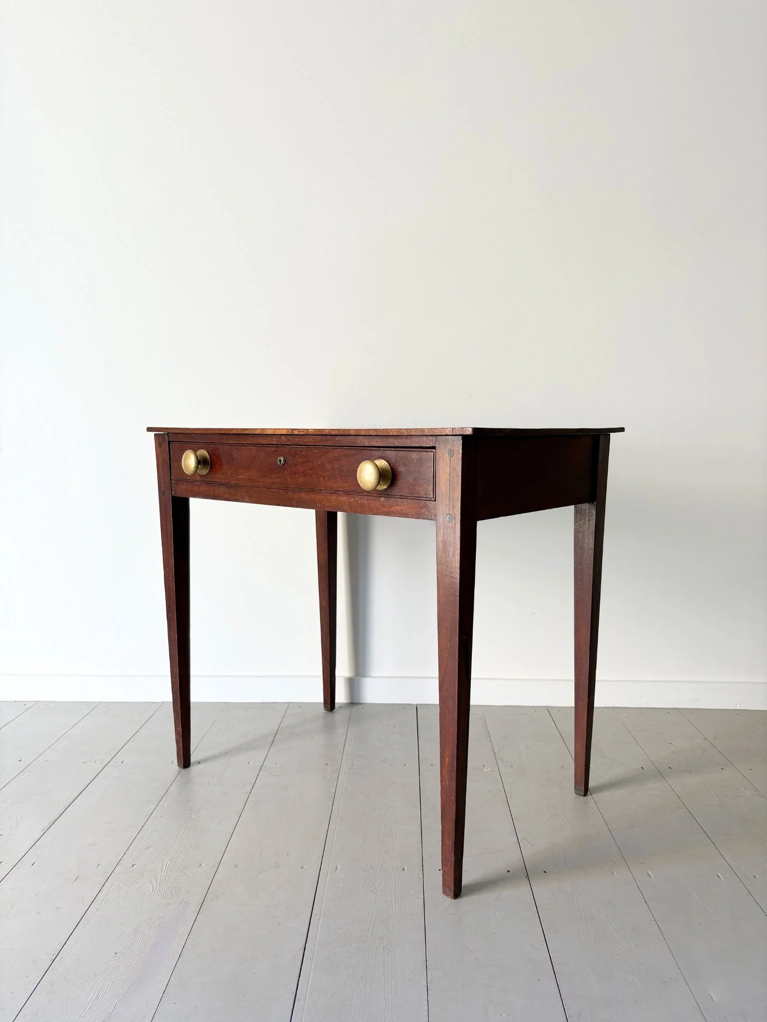 A 19th Century wooden side table with geometric inlay detail, elegant tapered legs, a single drawer and brass handles - Bureau Bruton