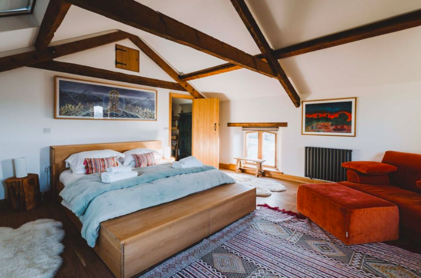 Small dark wooden cabin with open shutters in lush garden