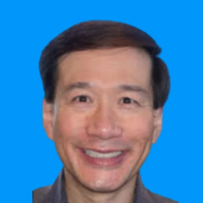 A smiling man with dark hair and light skin against a blue background.