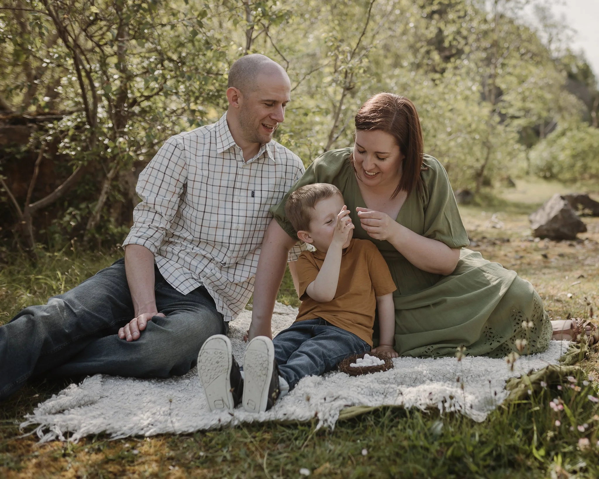 Photograph of a family enjoying a nest of mini marshmallows at my spring mini sessions large tree stump