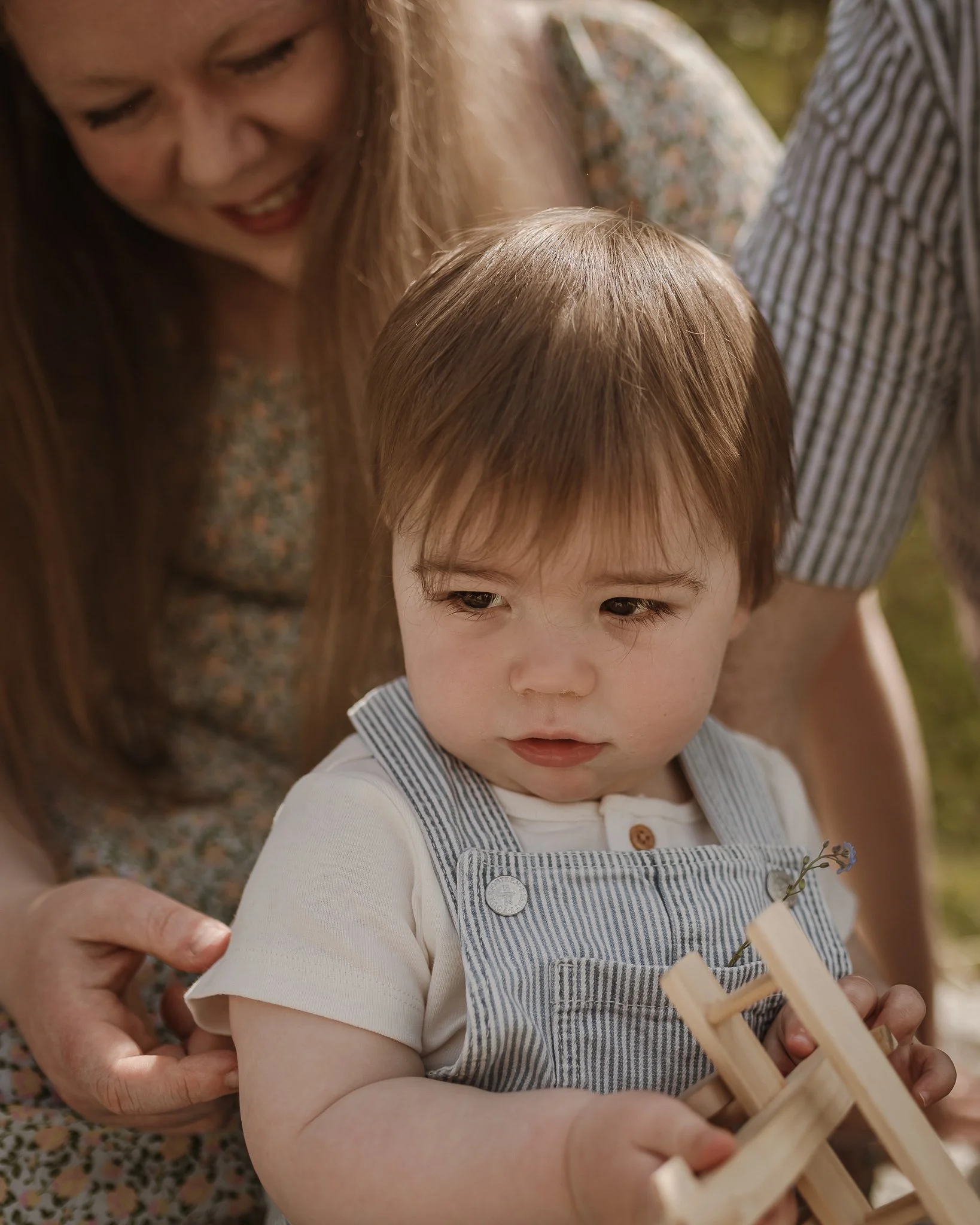 Baby Max playing with a wooden plane at my spring mini sessions