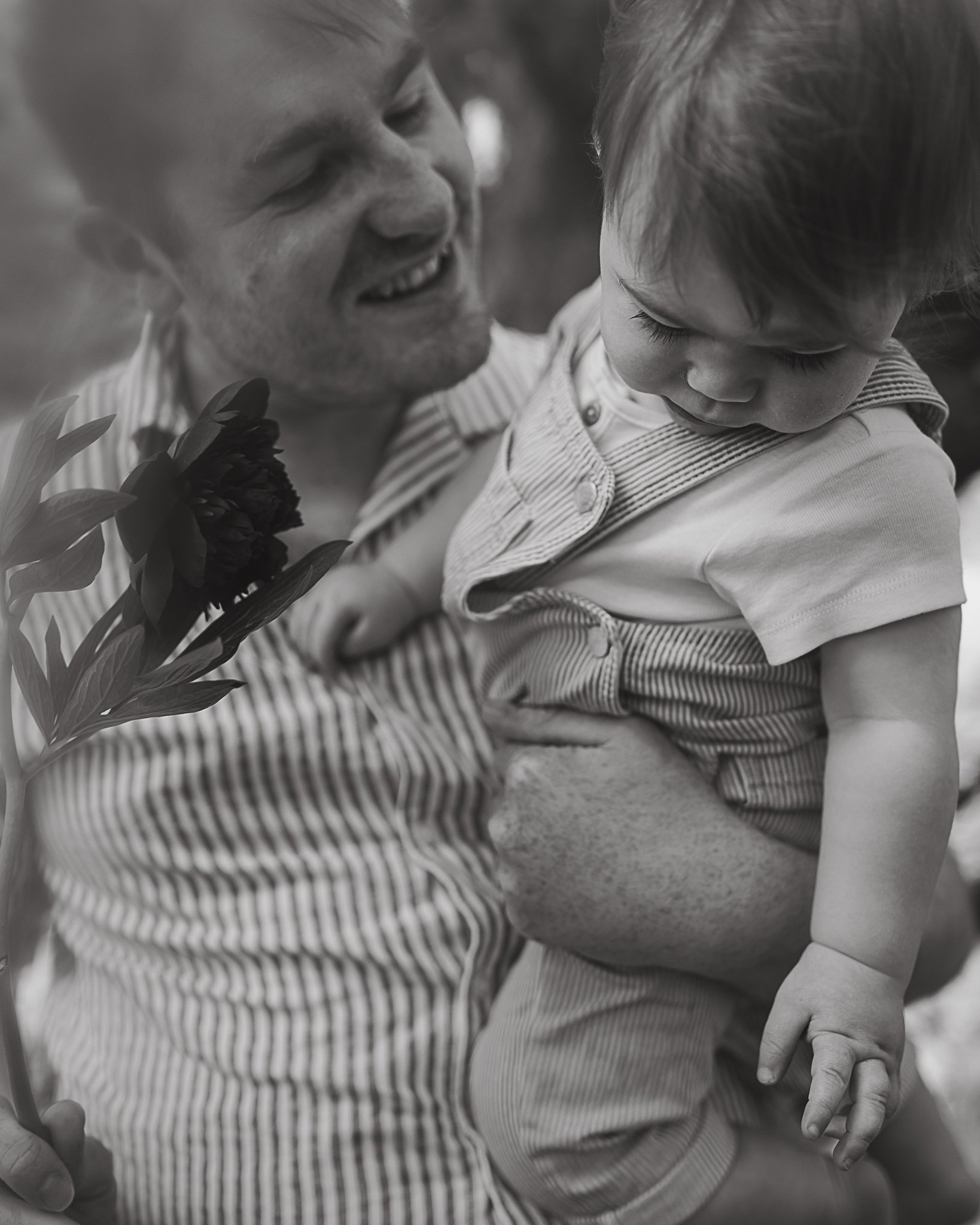 Photograph of a father holding his baby boy in black and white