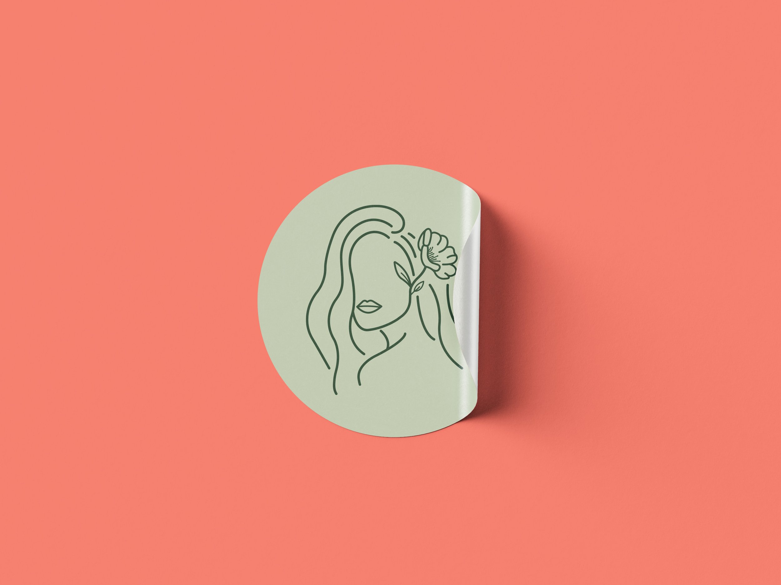 Flowerful Hair Salon brand identity round sticker mockup featuring a sage green circular sticker with a dark green fine-line illustration of a woman with long flowing hair holding a flower, peeling at the corner, on a coral pink background.