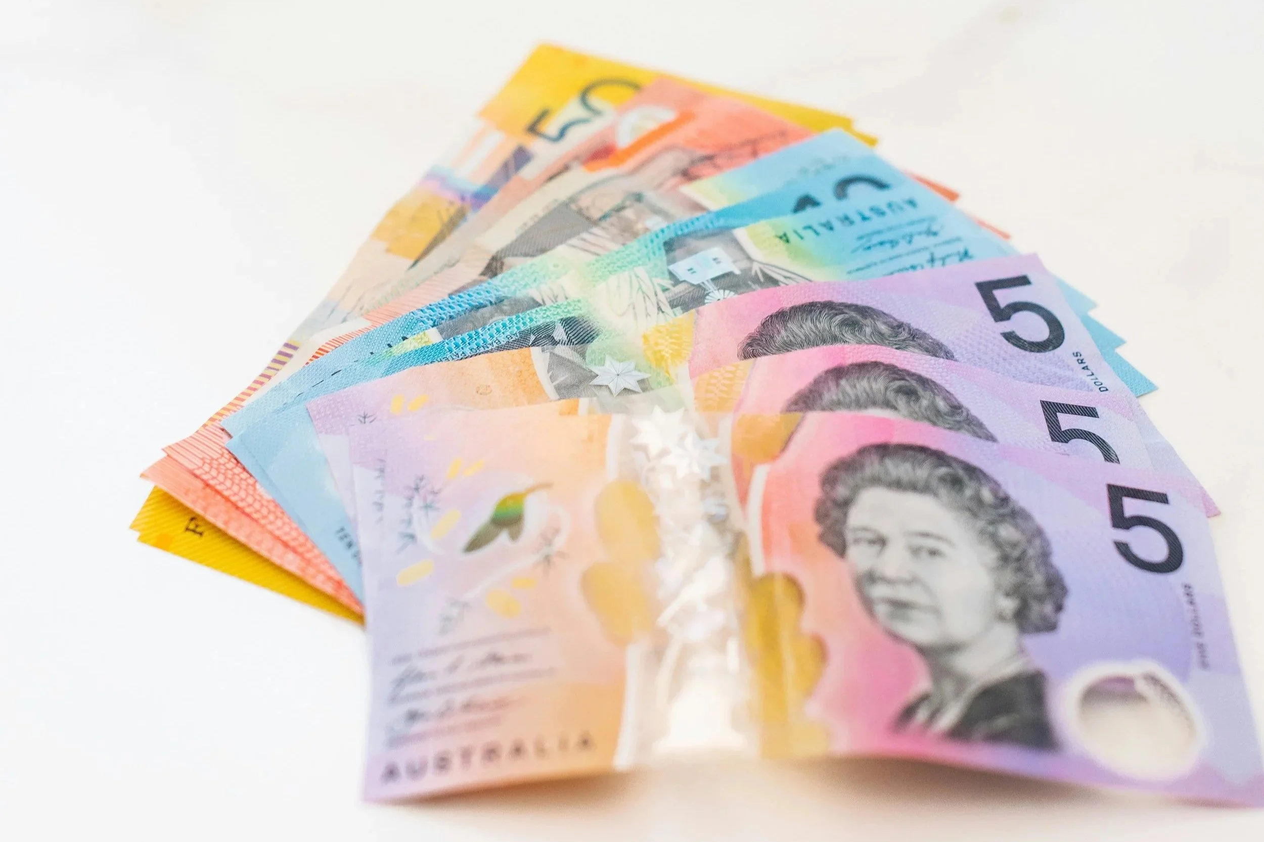 fanned out Australian Dollar notes on a white background