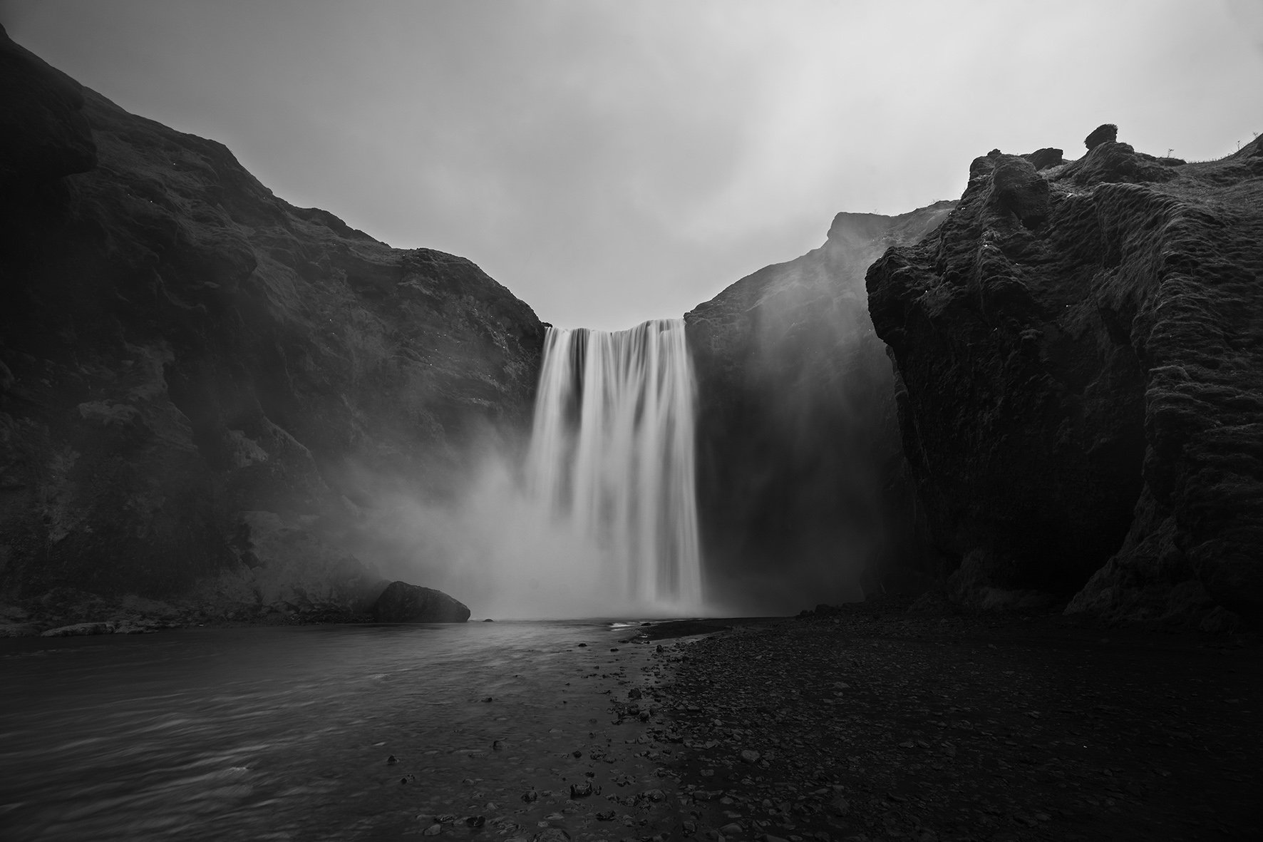 Skógafoss waterfall in Iceland, slow shutterspeed enhances the dramatic and majestic power of the water hitting the riverbed on a dark and cloudy, misty day.jpg