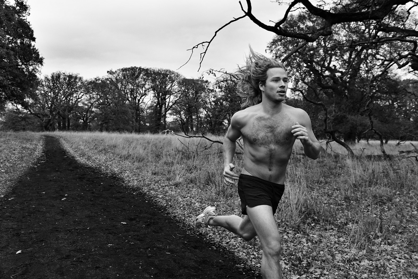 Male runner with long hair, bare chested in shorts, running on gravel road in nature park | Dyrehaven.jpg