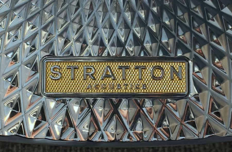 Close-up of a Stratton Acoustic luxury loudspeaker badge on a shiny chrome Element 6 loudspeaker stand base.