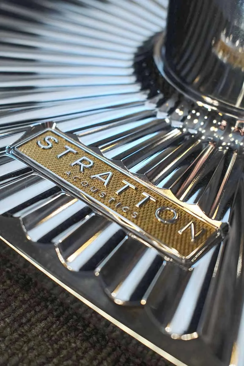 Close-up of a Stratton Acoustic luxury loudspeaker badge on a shiny chrome Element 8 loudspeaker stand base.