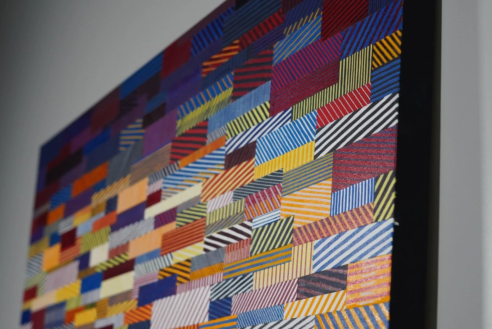 Angled detail of Rumination: Chaos Theory, showing canvas texture and intersecting red, blue, yellow, and white lines.
