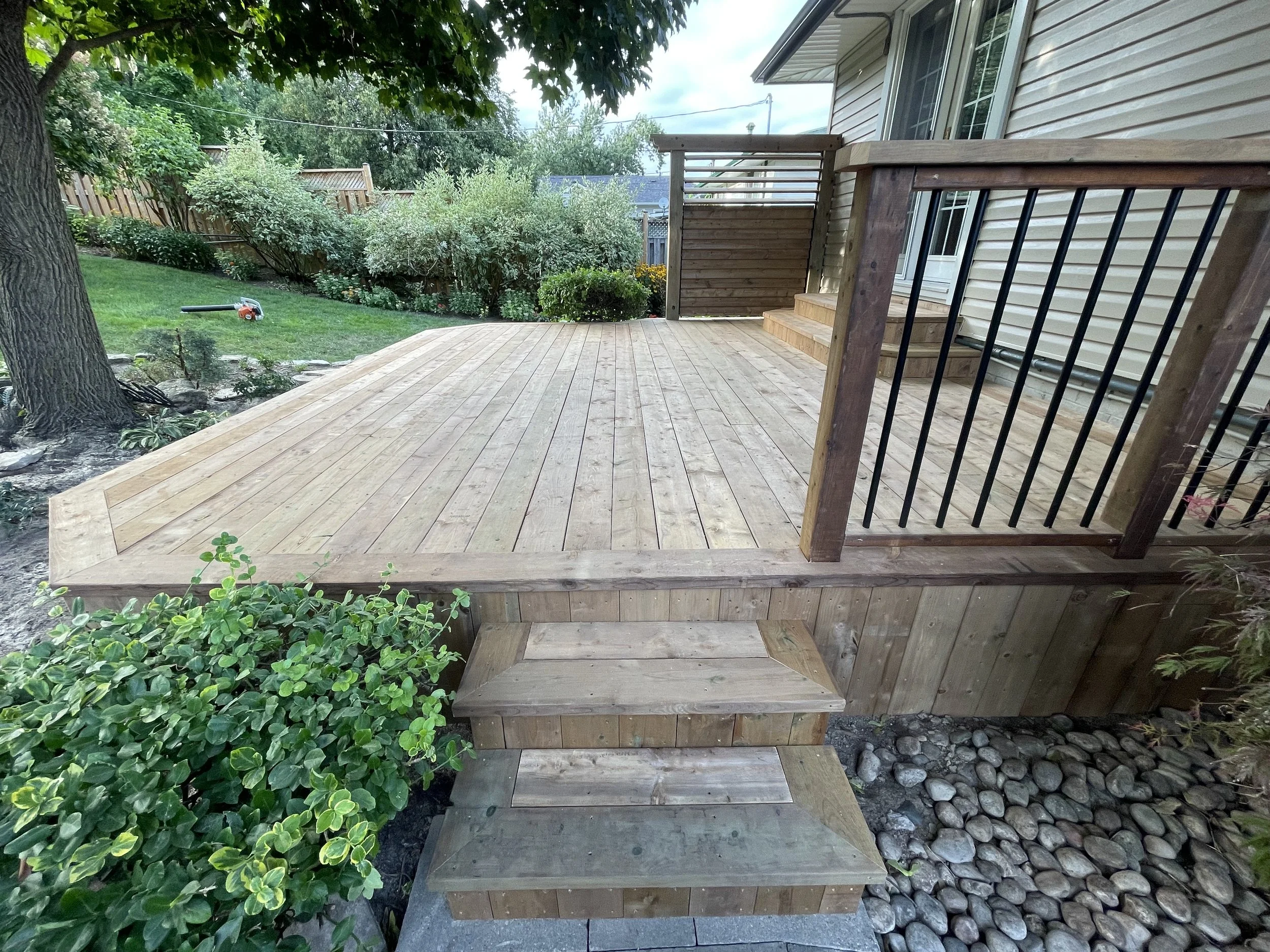 pressure-treated-wood-backyard-deck-black-spindle-railing